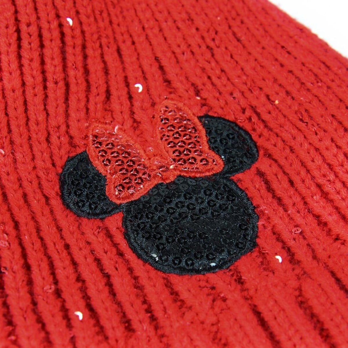 Primer plano de tejido de punto rojo con un lazo de lentejuelas de Minnie Mouse y orejas negras de Mickey Mouse.