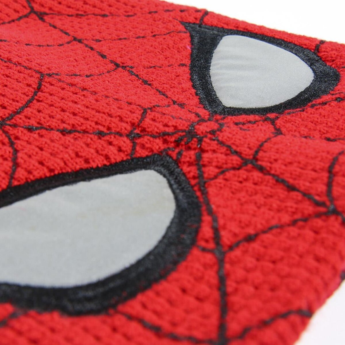 Primer plano de una máscara roja de Spiderman. La máscara tiene formas de ojos blancos delineadas en negro y un diseño de telaraña negro.
