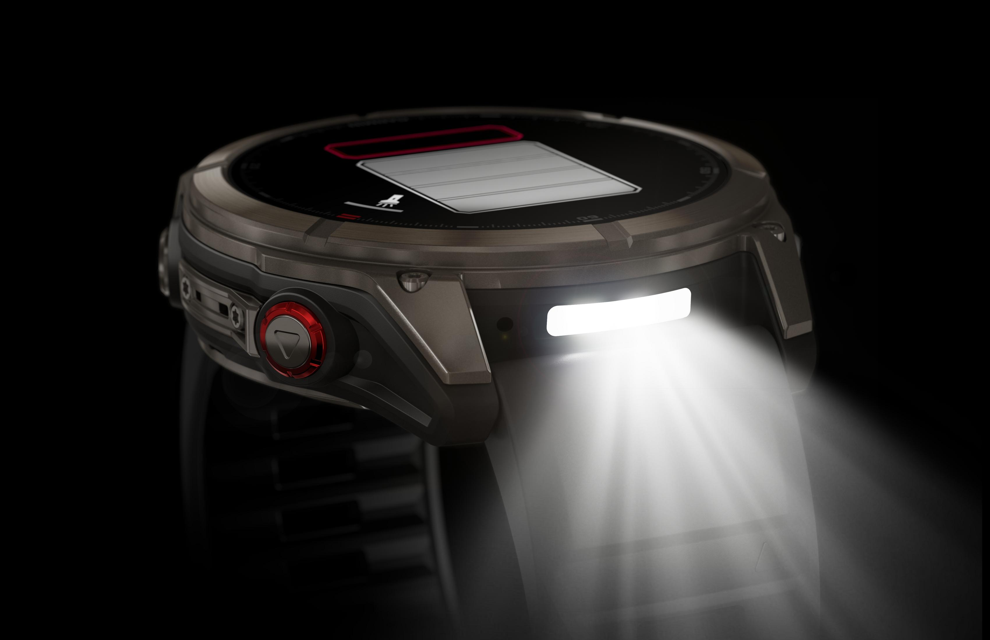 Eine Smartwatch mit schwarzem Bildschirm, der ein Batteriesymbol anzeigt. Sie hat eine rote Taste und ein helles Licht.