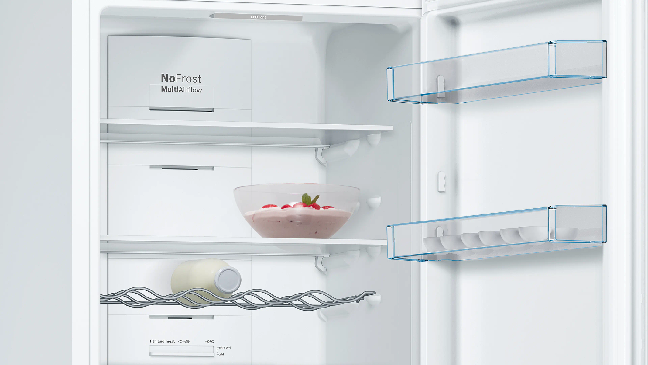 Interno del frigorifero aperto. Contiene ripiani, una ciotola con dessert rosa, bottiglia di latte e contenitori per uova. Interno bianco e dettagli blu.
