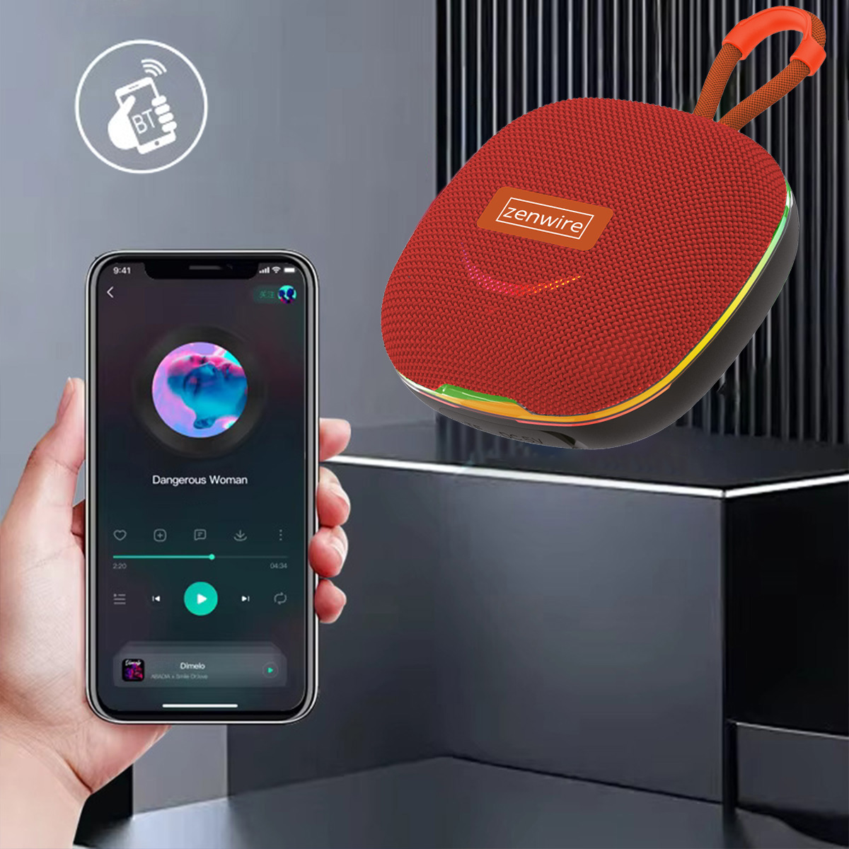 Ręka trzyma telefon odtwarzający muzykę, połączony z czerwonym głośnikiem. Głośnik ma pomarańczowy uchwyt, telefon pokazuje 'Dangerous Woman'.