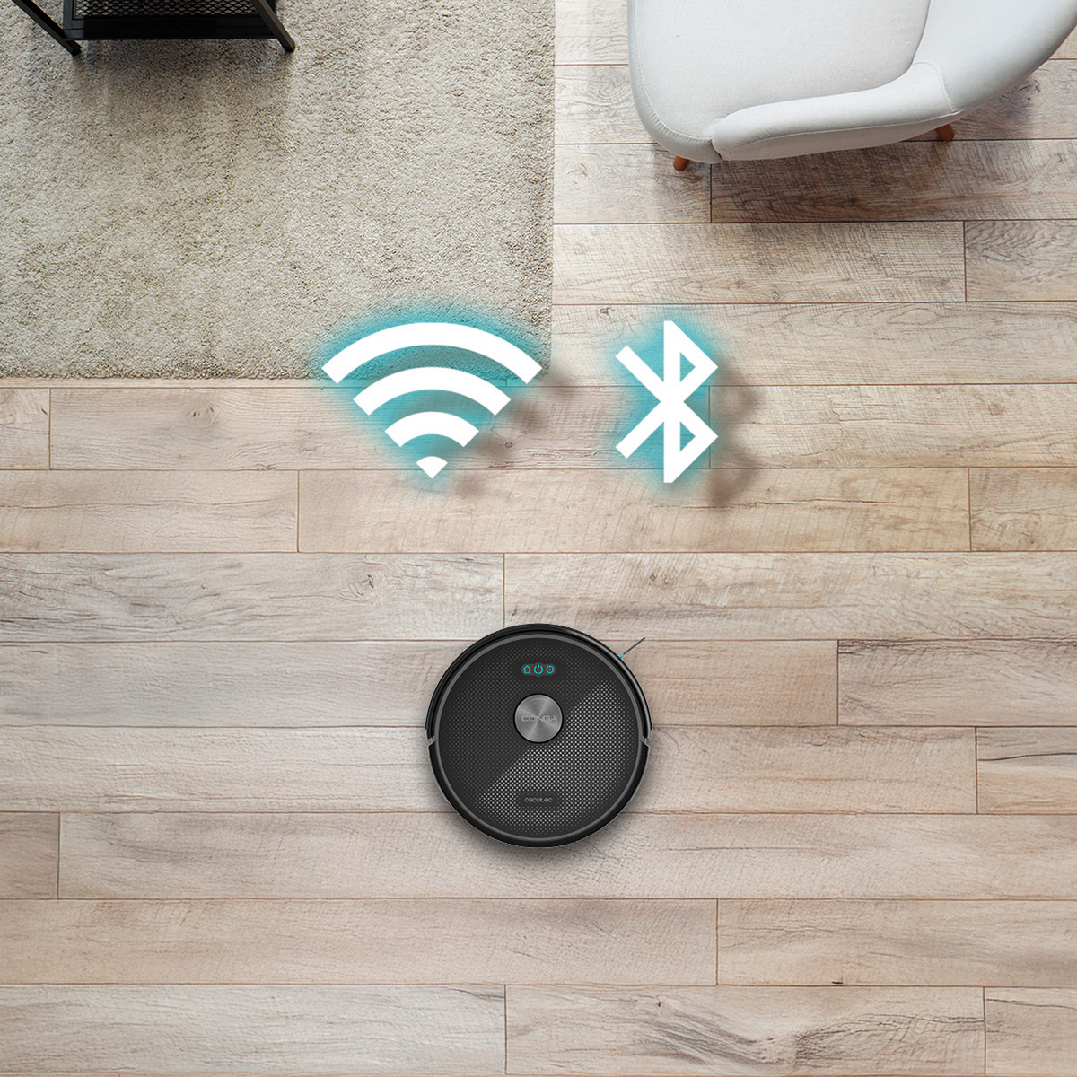 Una vista dall'alto mostra un aspirapolvere robot nero su pavimenti in legno. I simboli Wi-Fi e Bluetooth si illuminano sopra.
