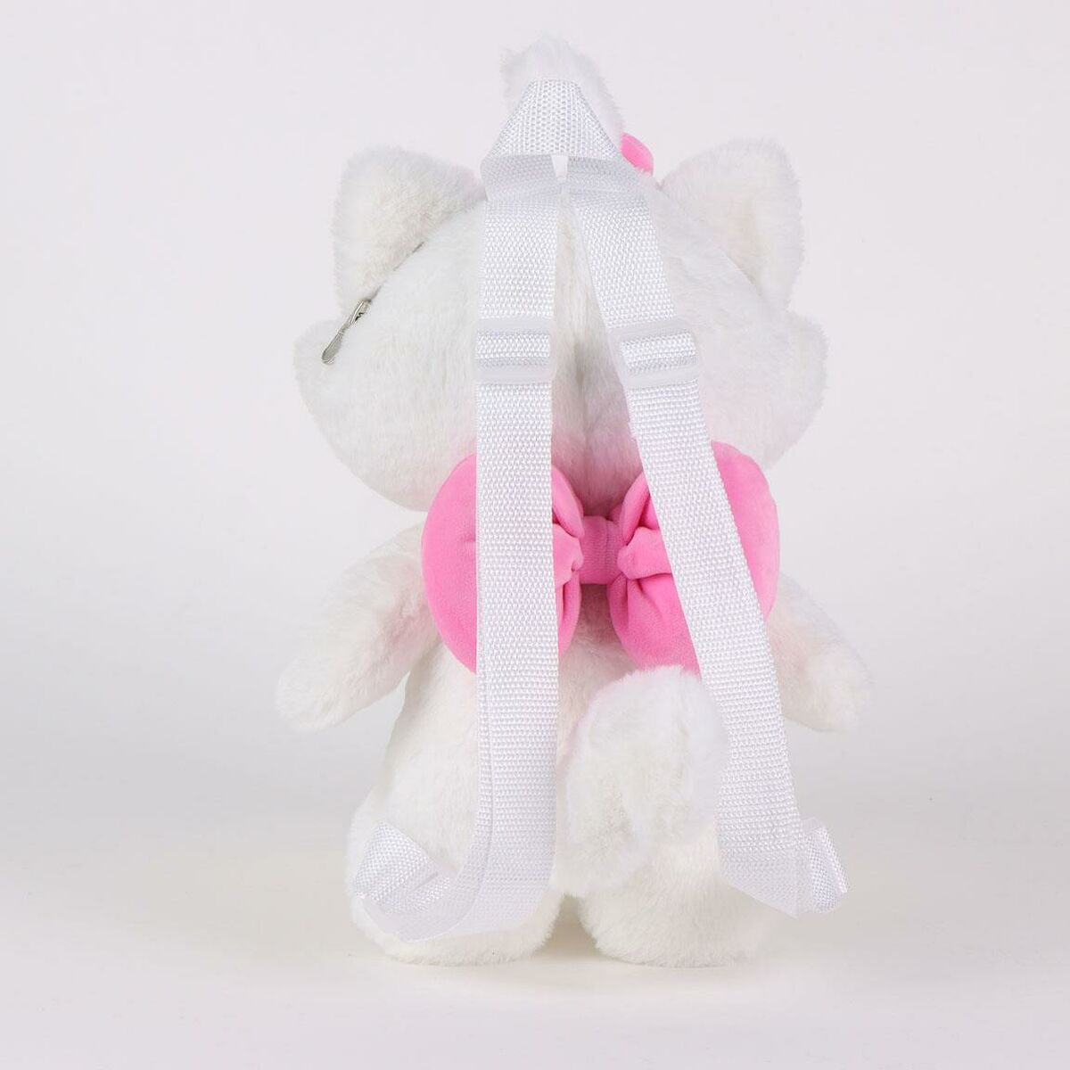 Una mochila de gato blanco con lazo rosa y correas blancas. Está sobre un fondo blanco. La espalda del gato está mirando al espectador.