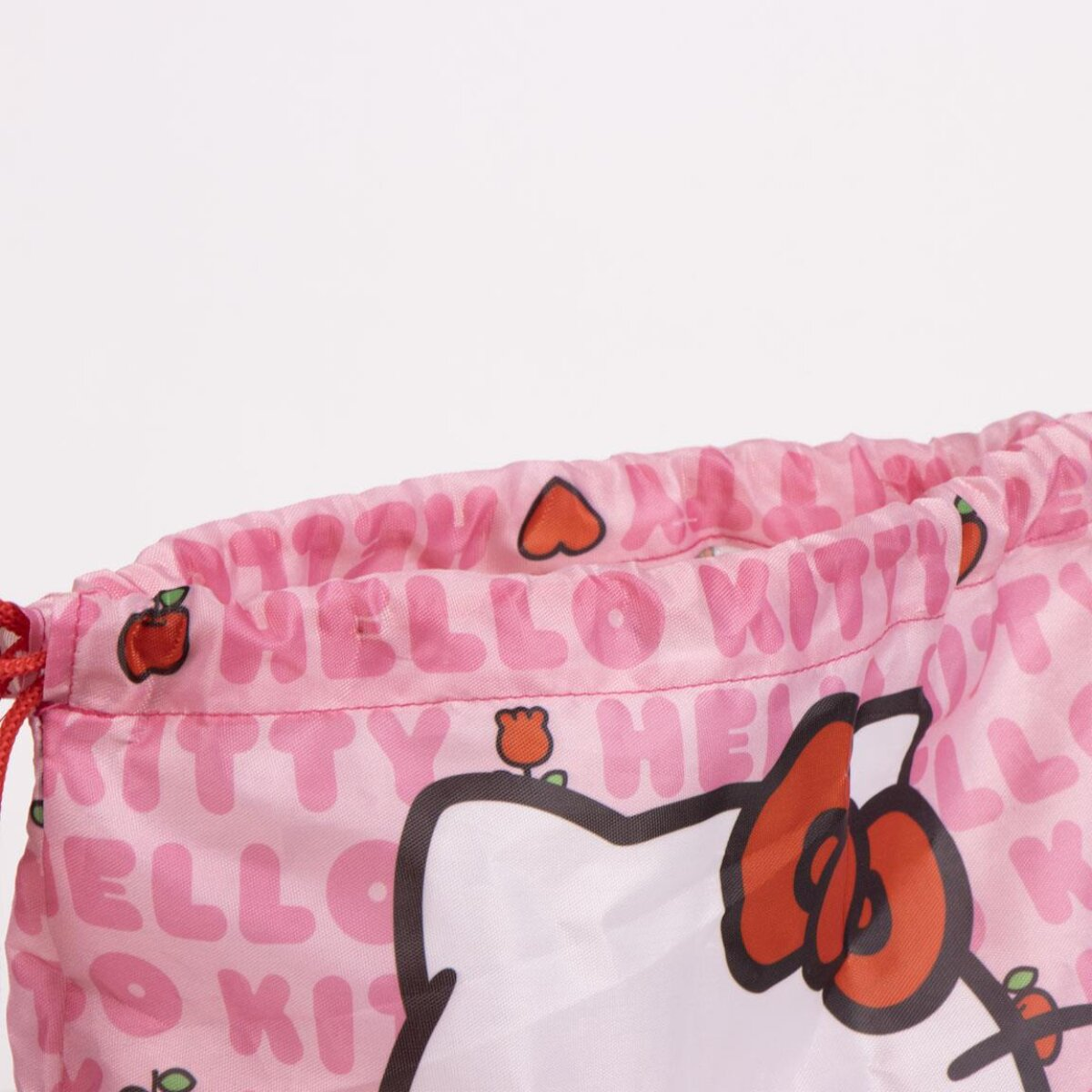 Bolsa rosa de Hello Kitty con lazo y nombre. Tiene cordones rojos y diseños de manzana y flores.