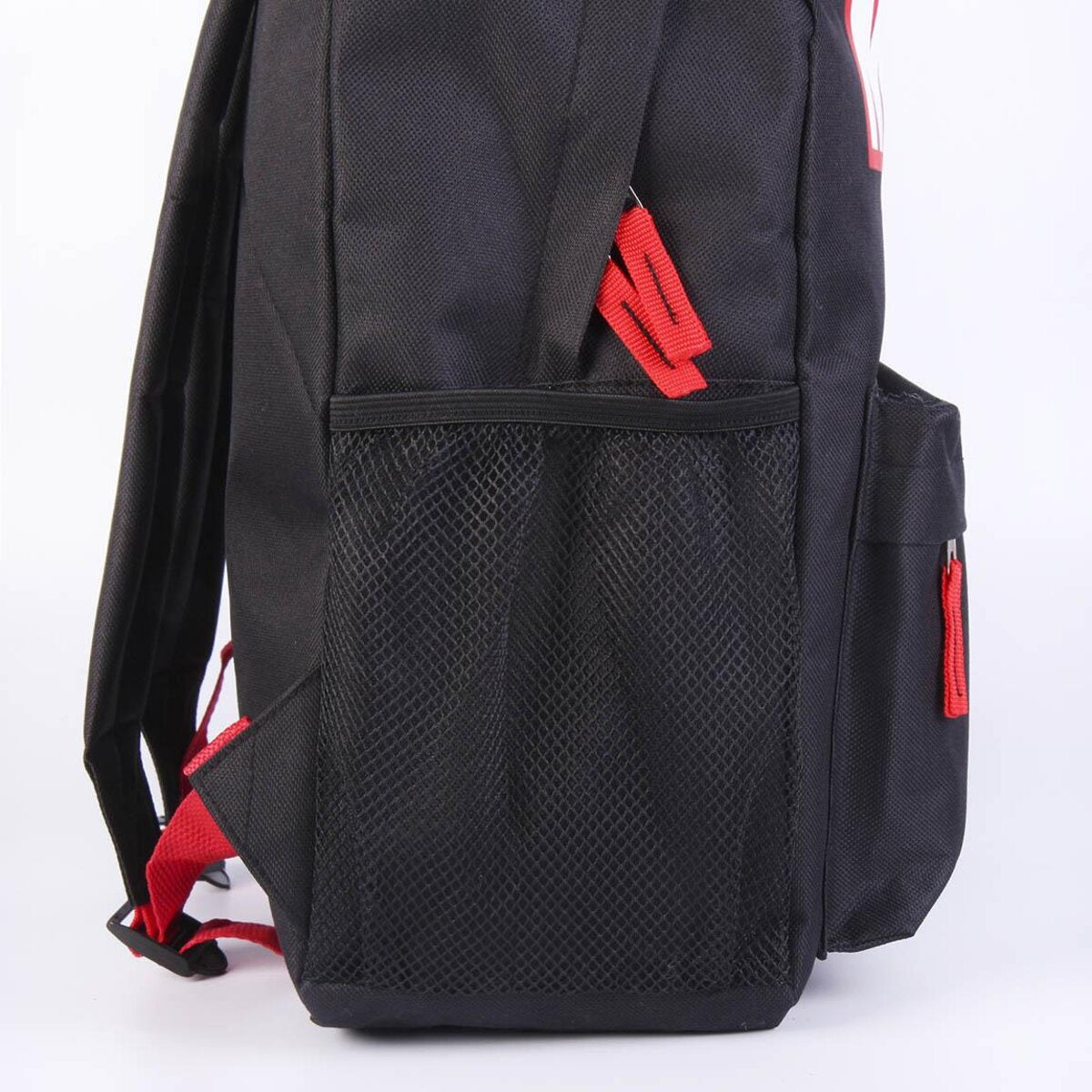 Mochila negra con correas rojas y un bolsillo lateral de malla. La cremallera es roja. El fondo es blanco.