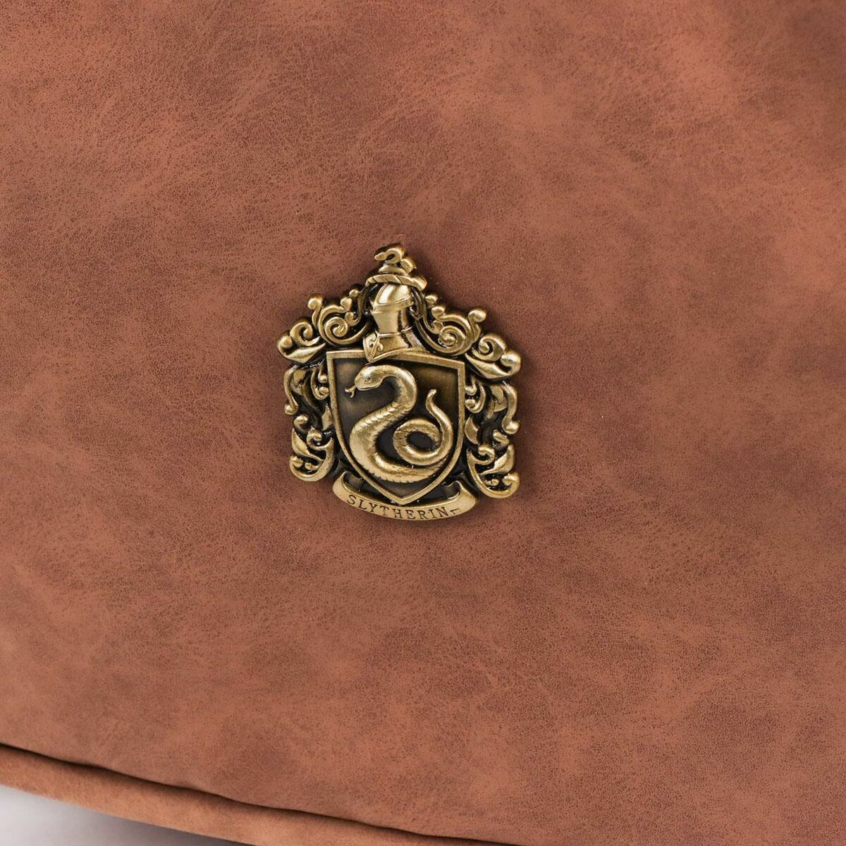 Superficie marrón con un escudo de Slytherin dorado. El escudo presenta una serpiente y la palabra 'Slytherin'.