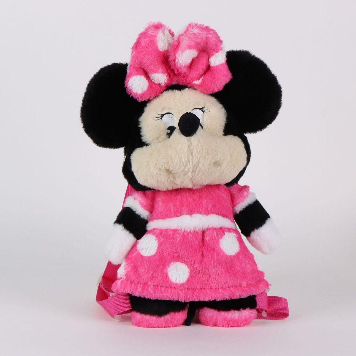 Una mochila de Minnie Mouse con un vestido rosa, lunares blancos, orejas negras y un gran lazo rosa.