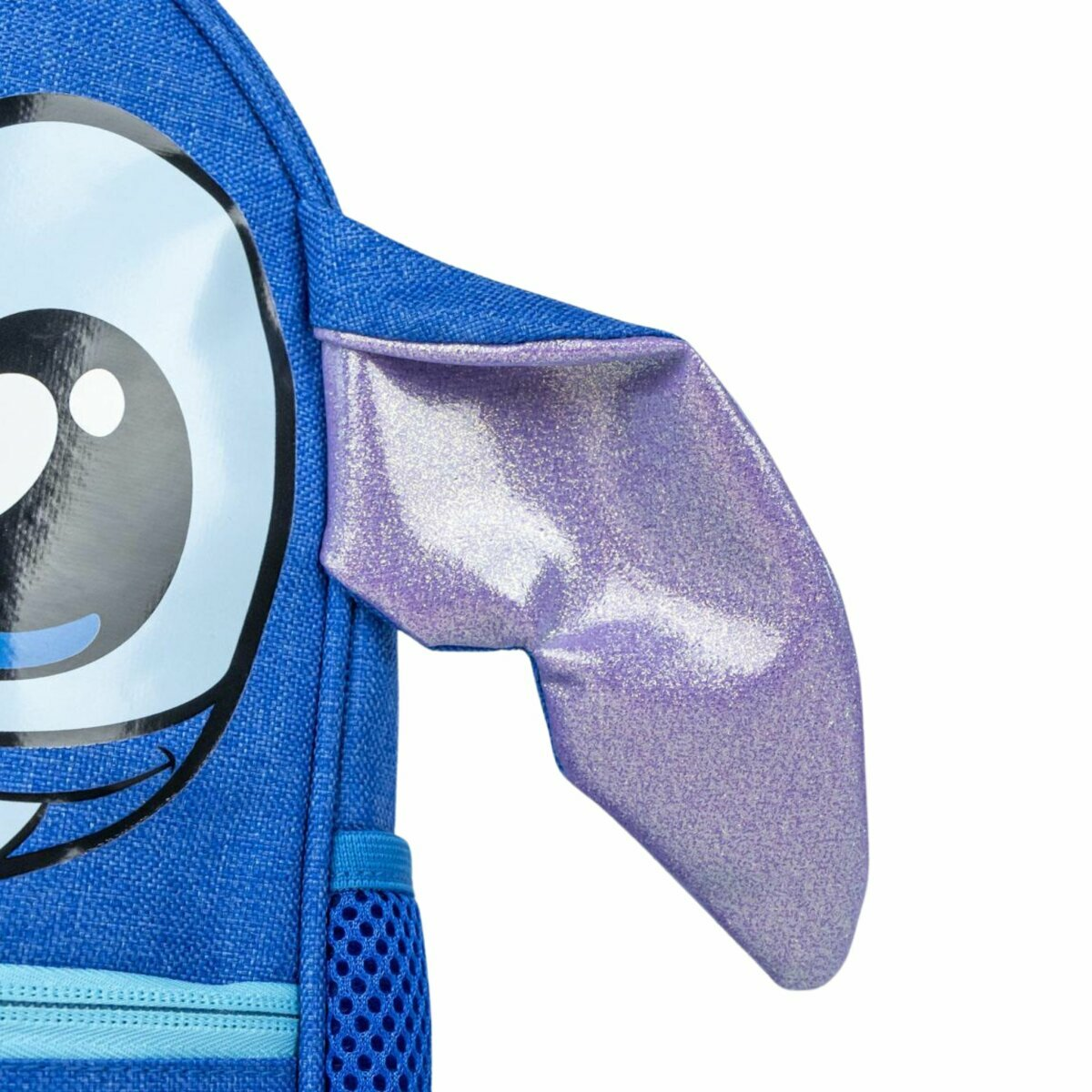 Primer plano de una mochila de Stitch. La mochila azul presenta un ojo de Stitch y una oreja morada brillante. El fondo es blanco.