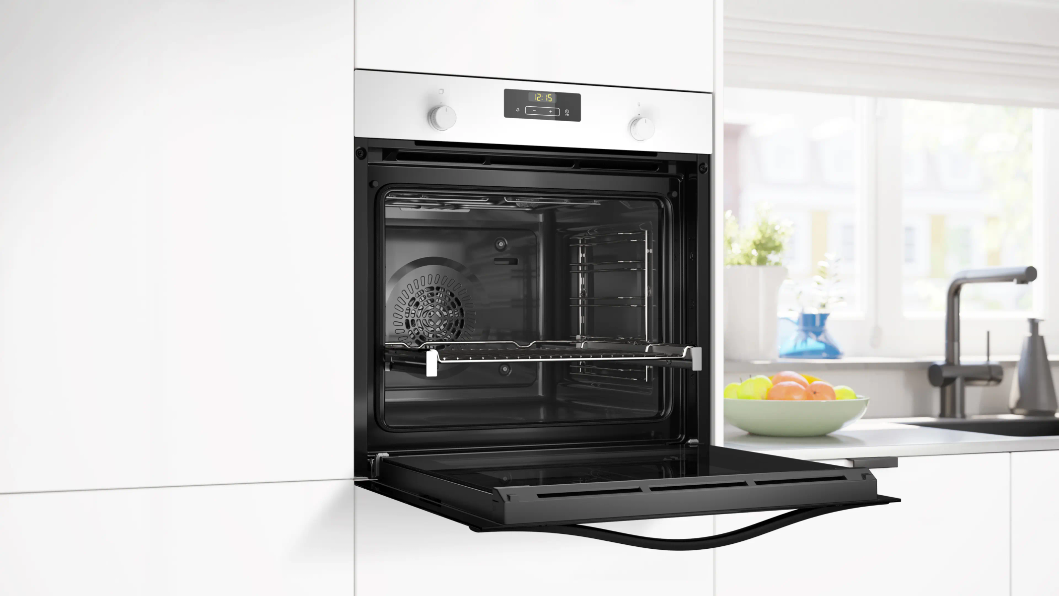 Un forno aperto con display digitale. Una ciotola di frutta sul bancone e una finestra visibile.