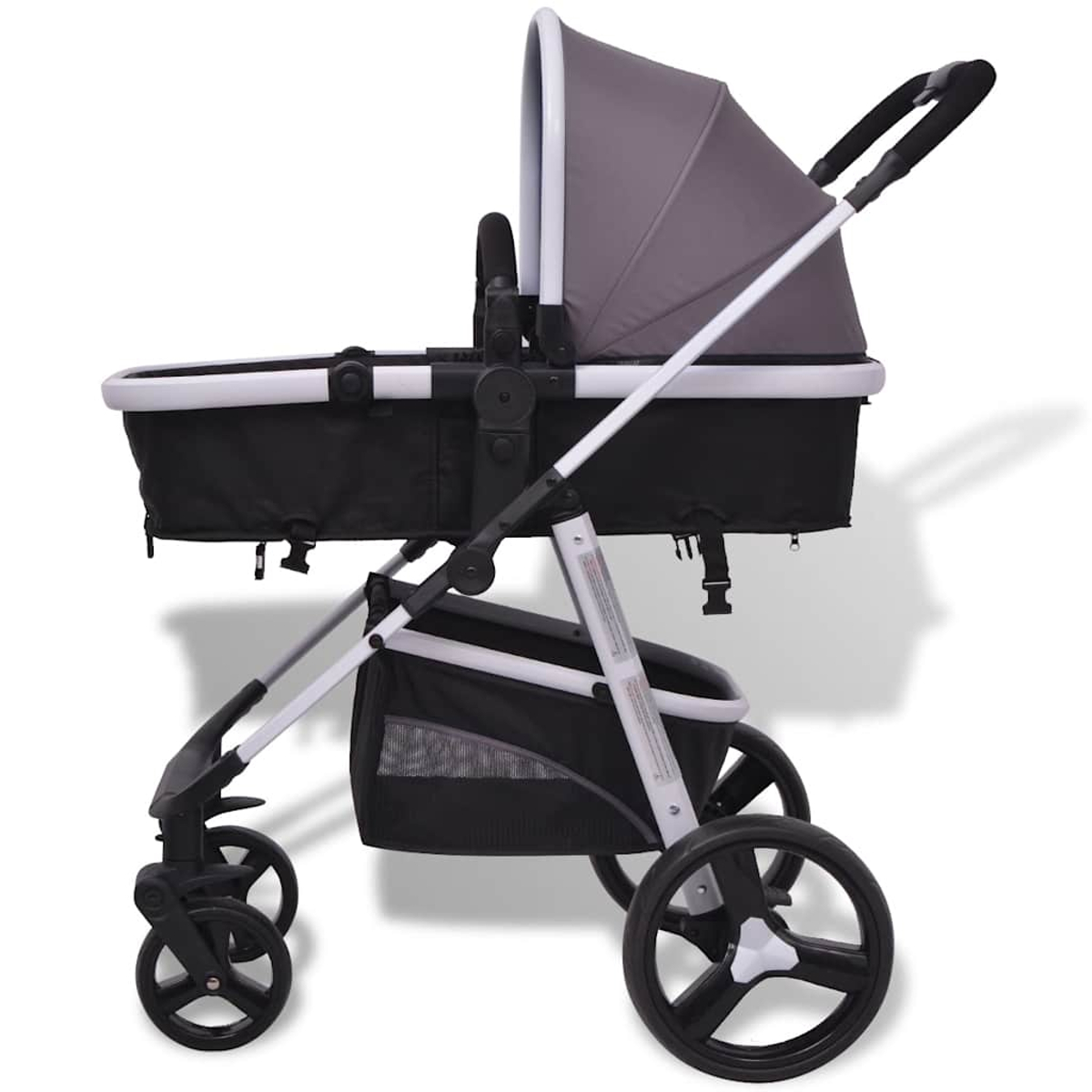 Ein grauer und schwarzer Kinderwagen mit weißen Akzenten. Er hat ein Verdeck, einen Einkaufskorb und vier Räder. Der Kinderwagen steht auf weißem Hintergrund.