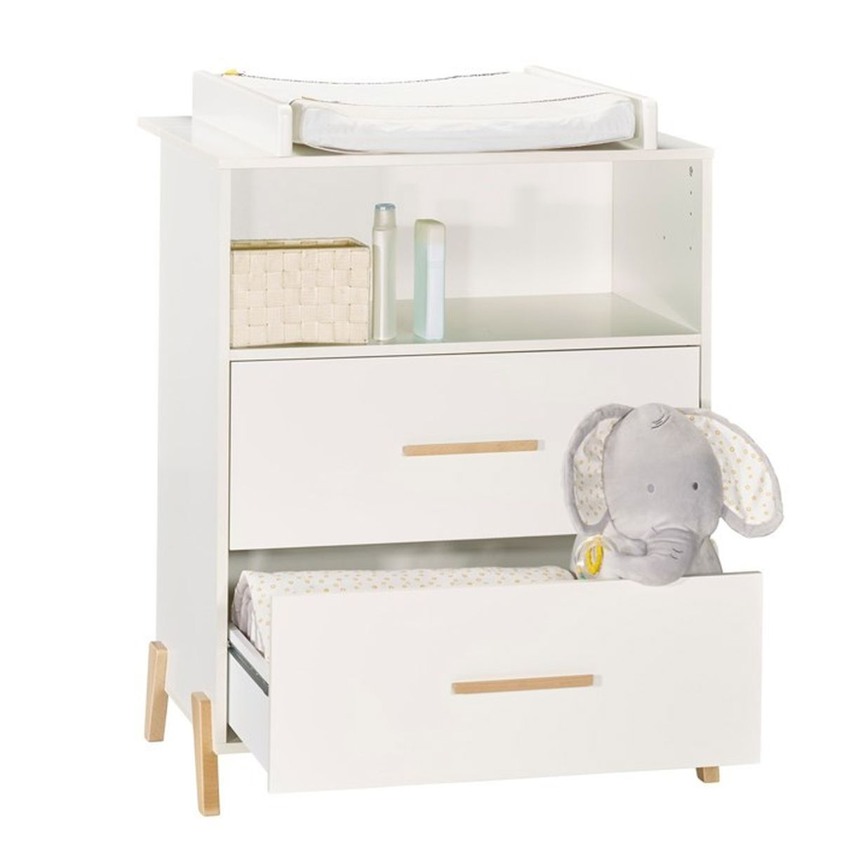 Ein weißer Wickeltisch. Er hat Schubladen, Regale und eine Wickelauflage. Ein Plüschelefant-Spielzeug befindet sich in einer Schublade.