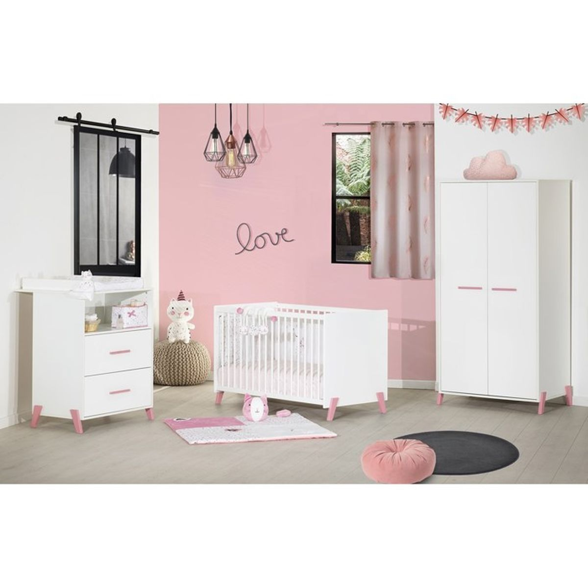Ein Babyzimmer mit weißen Möbeln, rosa Akzenten, einem Kinderbett, einer Wickelkommode und einem Kleiderschrank. Rosa Wände und Dekorationen.
