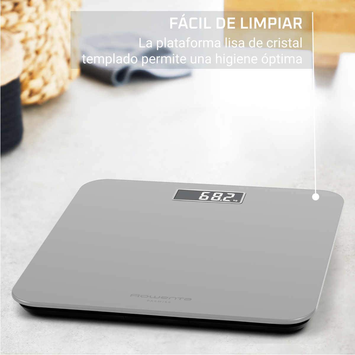 Una bilancia da bagno digitale grigia indica 68,2 kg. Il testo dice 'Facile da pulire'. Sullo sfondo un cesto di vimini.