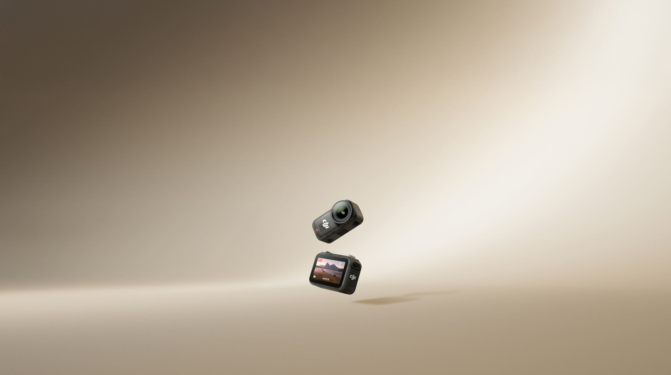 Dwie czarne kamery sportowe unoszące się w powietrzu. Jedna wyświetla scenę plenerową. Beżowe tło.