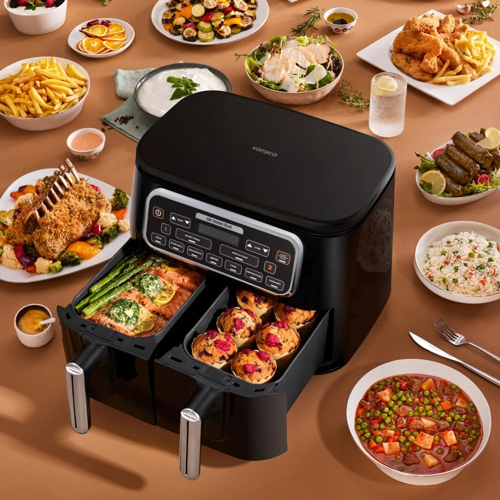 İki bölmeli siyah bir airfryer, çeşitli yemeklerle çevrilidir: kızartmalar, sebzeler, fırınlanmış ürünler, salatalar ve içecekler.