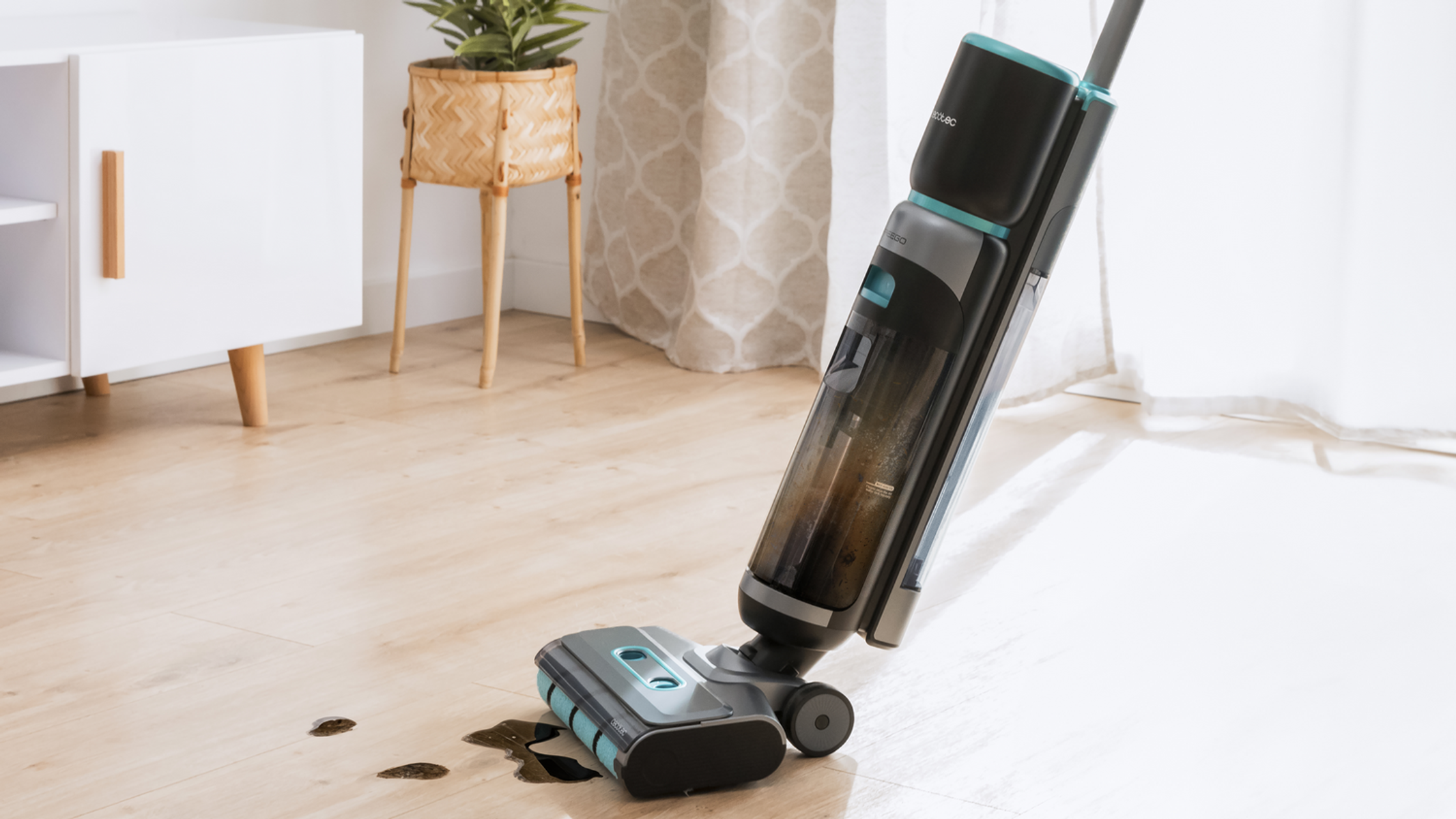 Un pulitore per pavimenti viene utilizzato su un pavimento in legno con macchie scure. Un mobile bianco, una pianta e una finestra sullo sfondo.