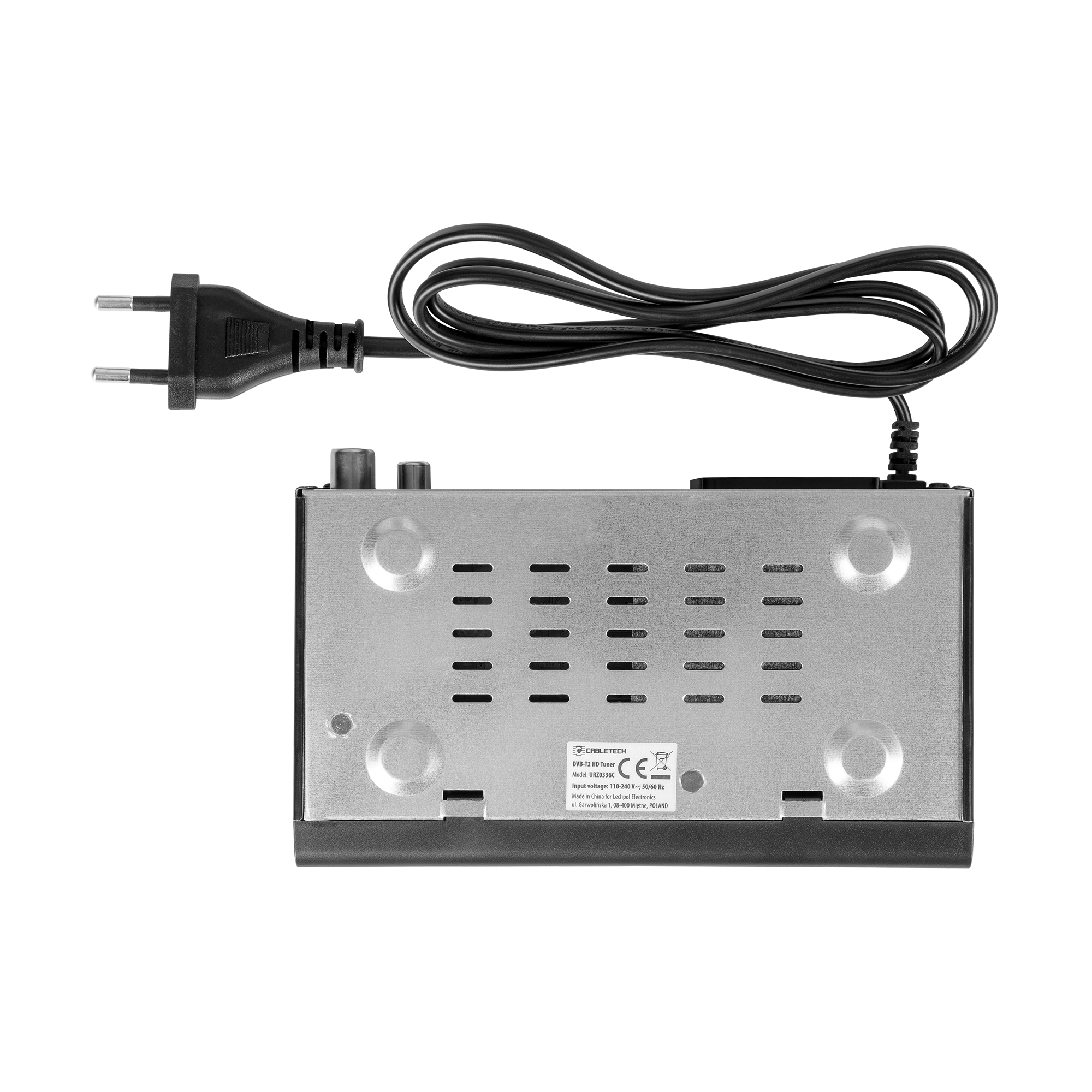 Czarny zasilacz z wtyczką i kablem jest podłączony do metalowego urządzenia z otworami wentylacyjnymi i etykietą.