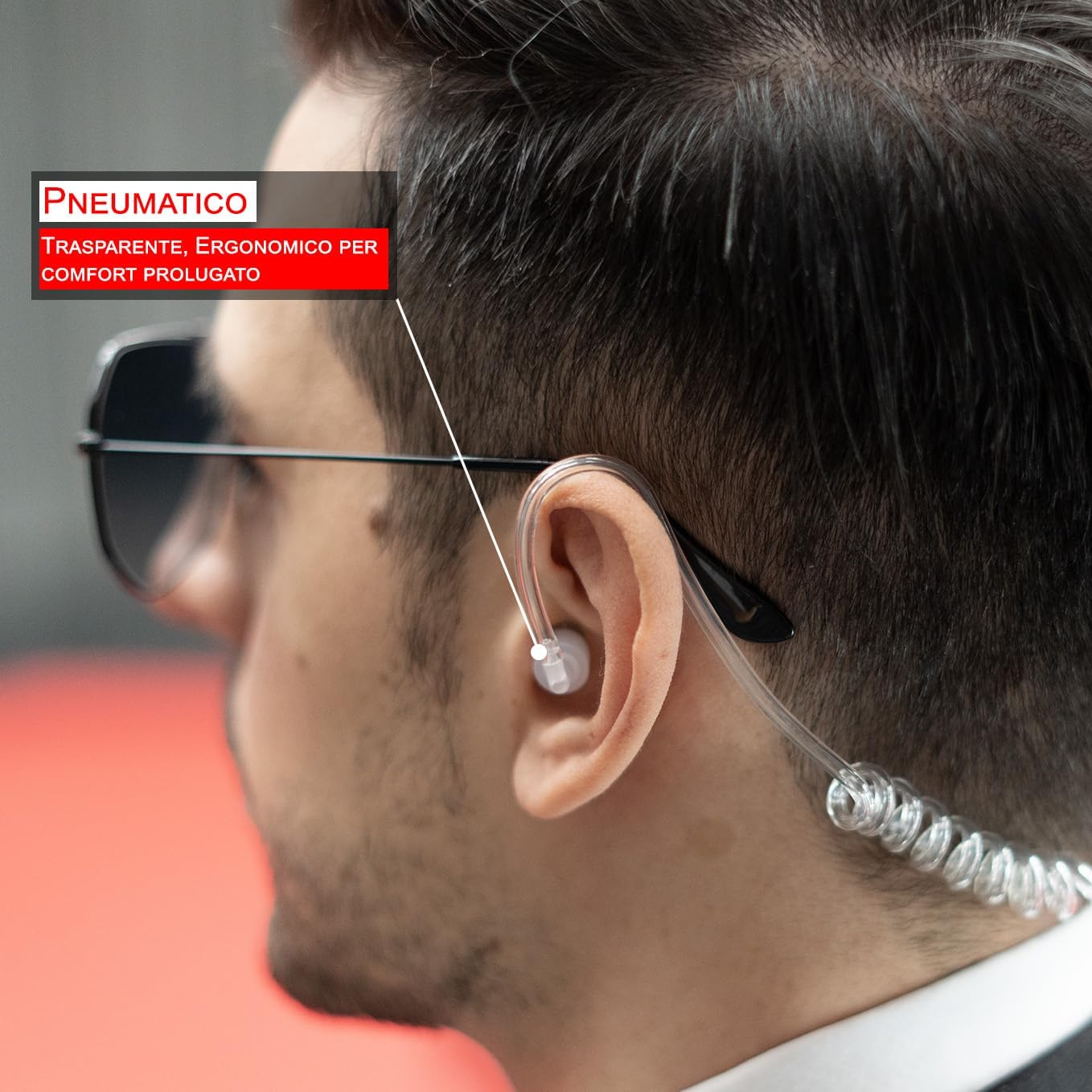 Un uomo con occhiali da sole e auricolare. Un riquadro di testo rosso dice 'PNEUMATICO, trasparente, ergonomico per comfort prolungato'.
