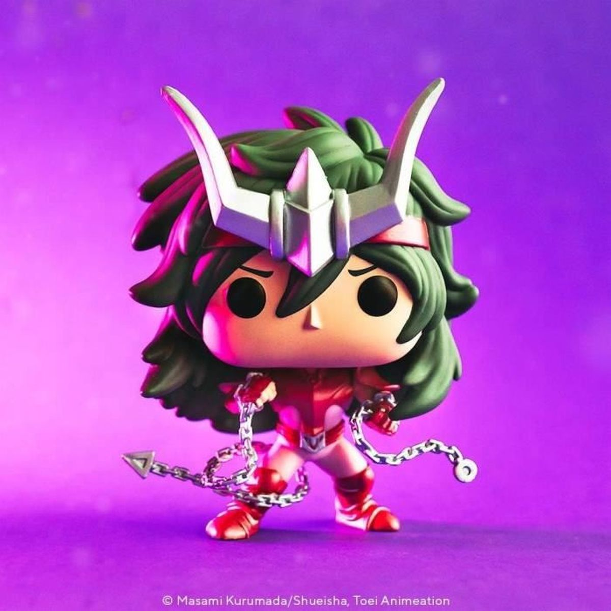 Una figura Funko Pop de un personaje de dibujos animados. Tiene pelo verde, casco plateado, armadura roja y sostiene cadenas con puntas de flecha sobre fondo morado.