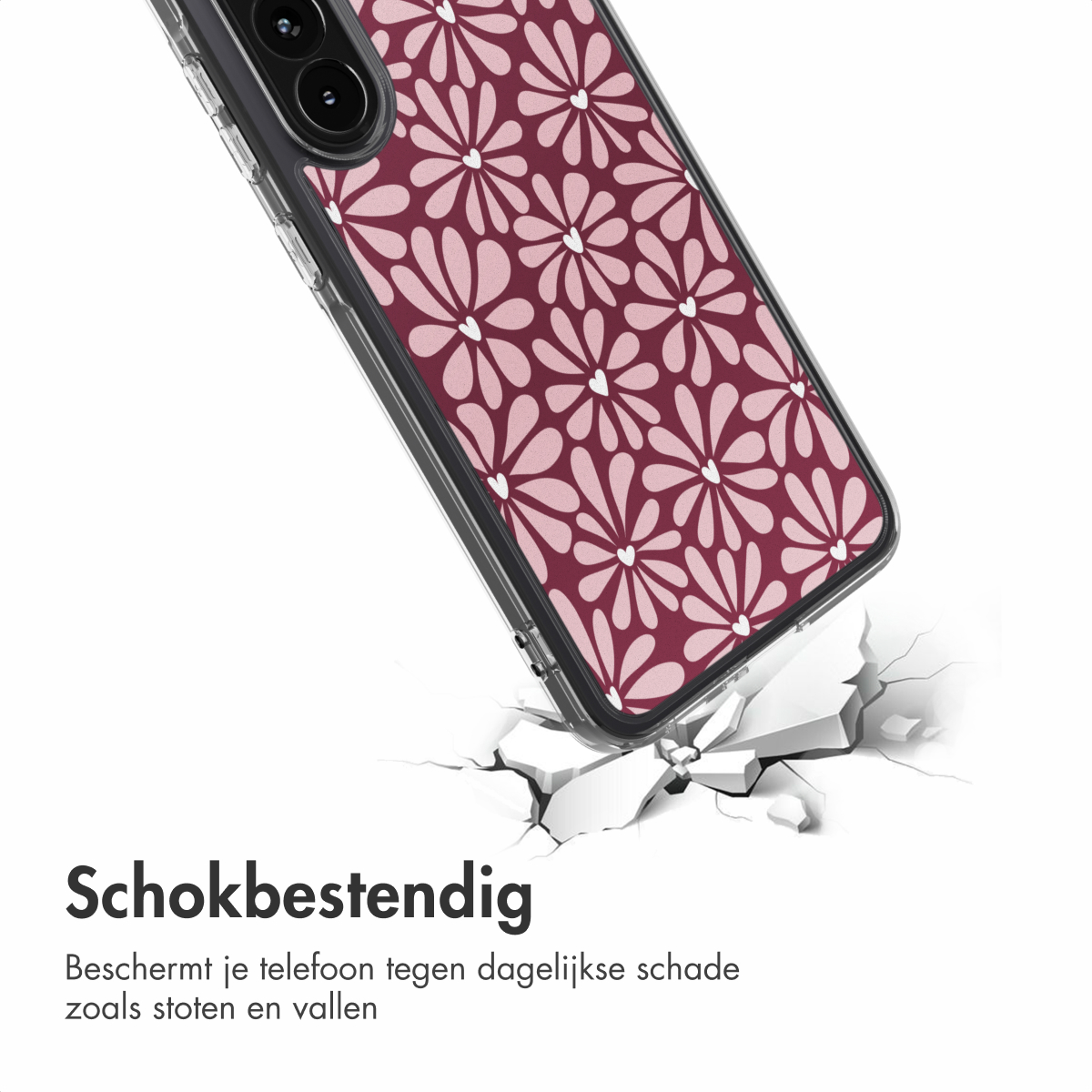 Een telefoonhoesje met bloemenpatroon breekt beton. De hoes is doorzichtig en heeft een bordeauxrood en roze bloemdesign.