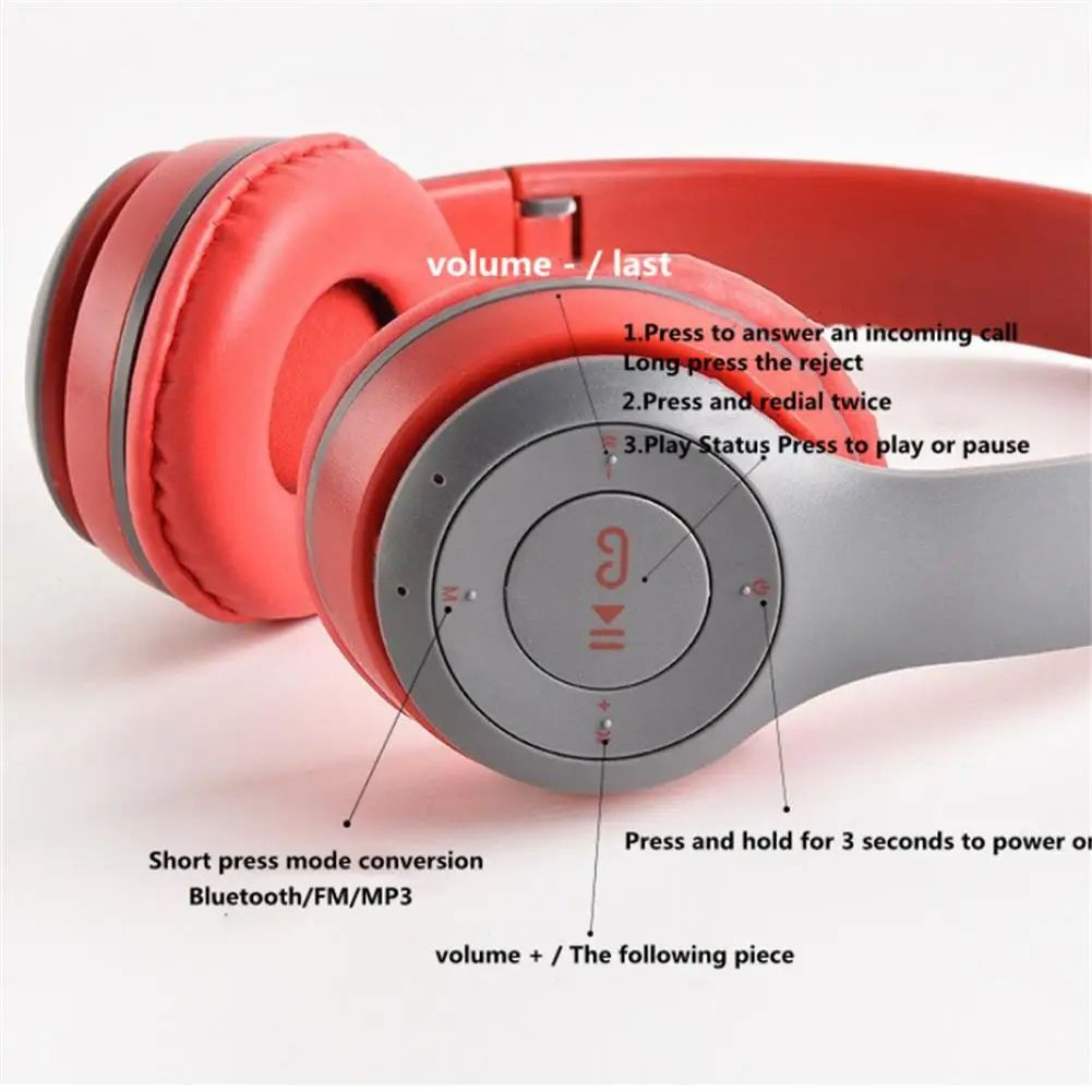 Auriculares rojos y grises con controles. Las etiquetas indican volumen, funciones de llamada y encendido. También está presente el modo Bluetooth/FM/MP3.