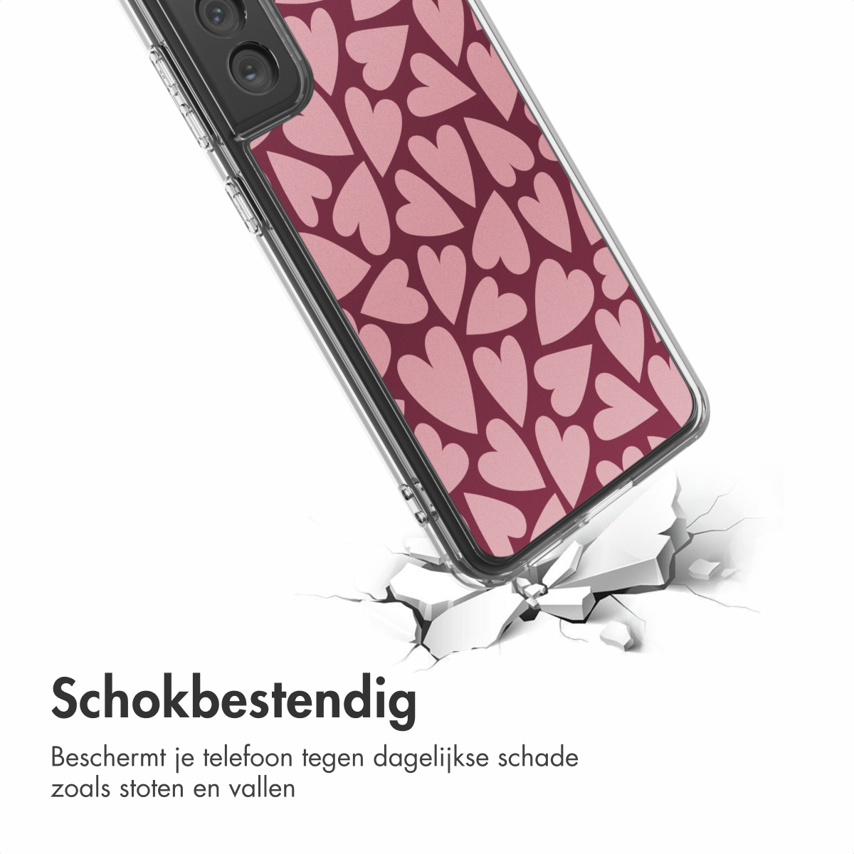 Un telefono in una custodia a forma di cuore rosa che rompe una superficie bianca. Il telefono è angolato. Il testo recita 'Schokbestendig'.