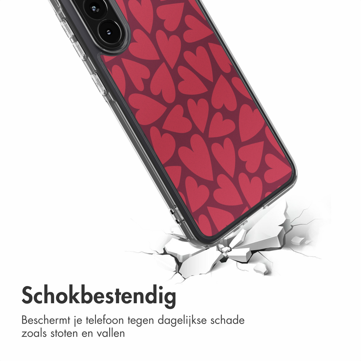 Een telefoonhoesje met een rood hartpatroon ligt op een gebarsten wit oppervlak. De hoes heeft een helder frame en een zwarte camera.
