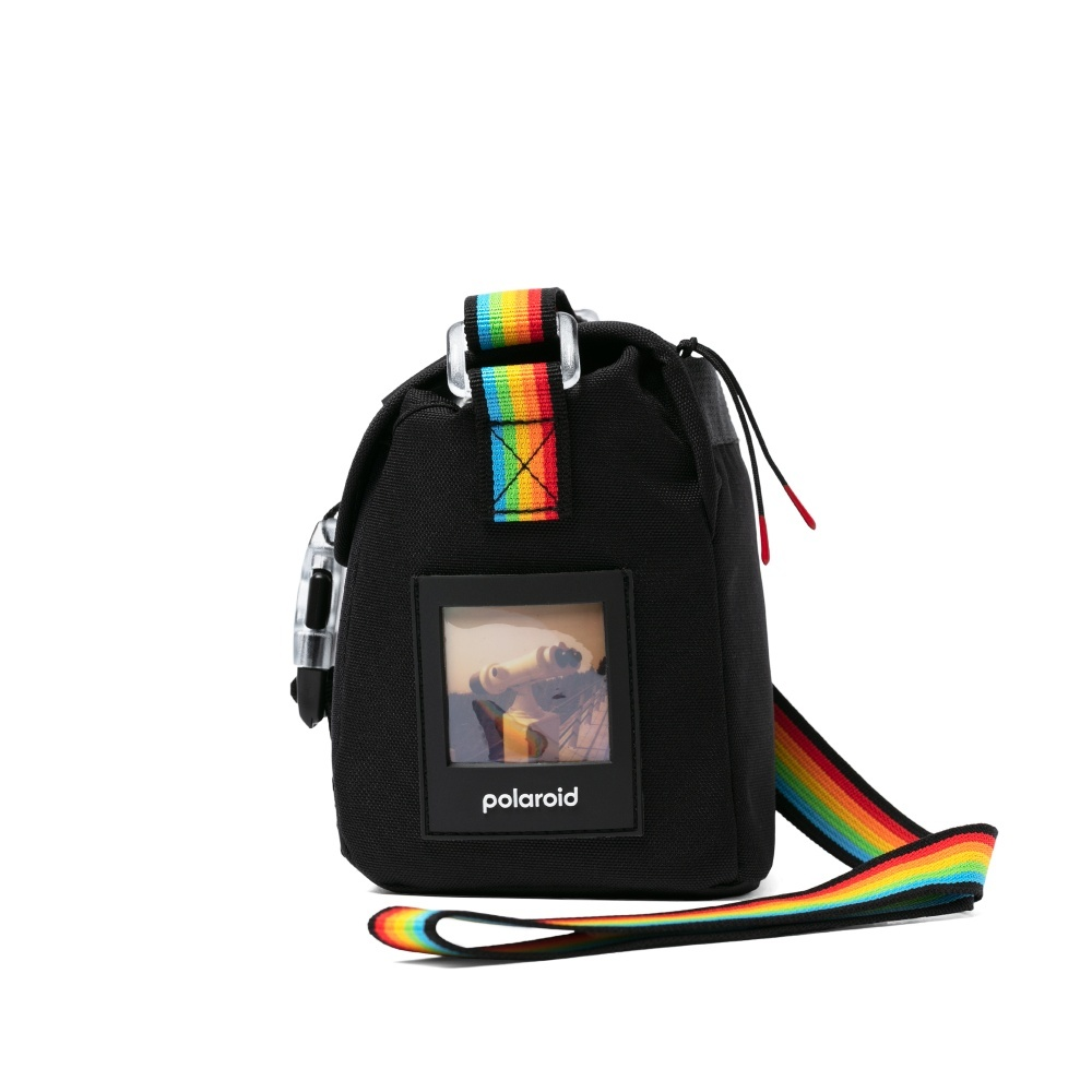 Schwarze Polaroid-Kameratasche mit Regenbogenriemen und Akzenten. Mit einem transparenten Fenster mit einem Bild und dem Polaroid-Logo.