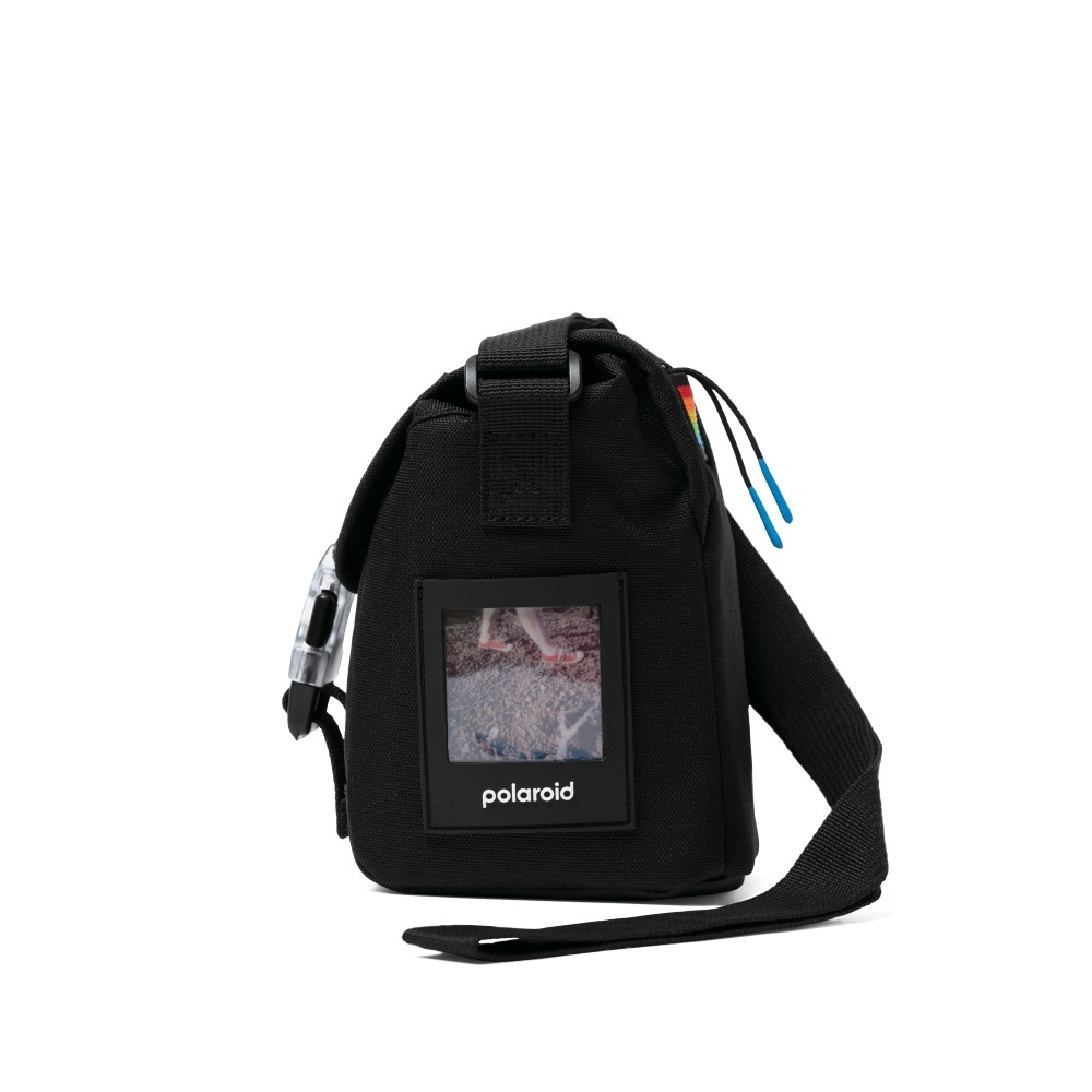 Schwarze Polaroid-Tasche mit Schulterriemen. Sie hat ein Fotofenster mit einem Bild von Füßen und dem Markenlogo.