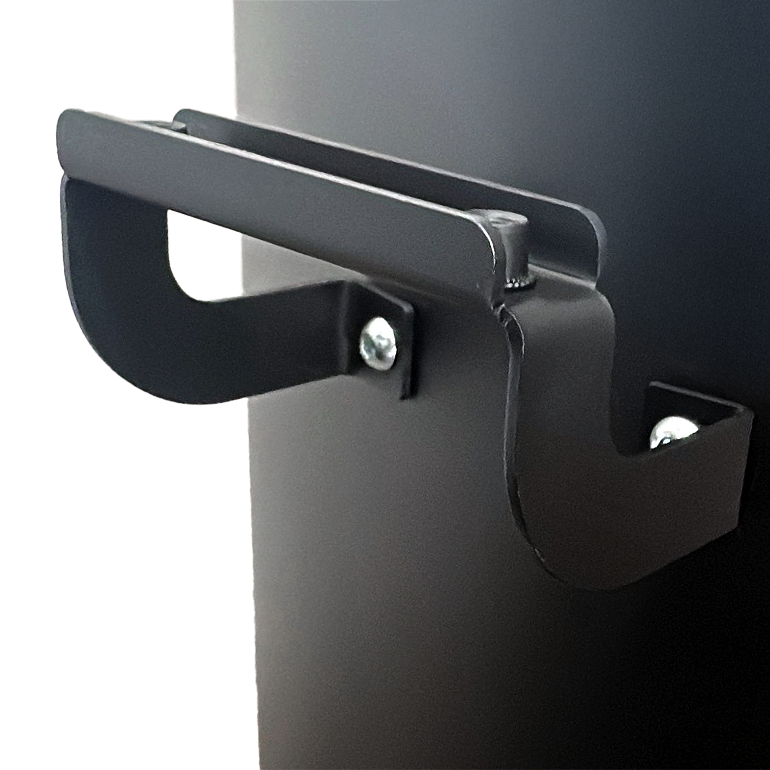 Nahaufnahme eines schwarzen Metallgriffs, der an einer schwarzen Oberfläche befestigt ist. Der Griff ist angeschraubt, mit gebogenem Design und silberner Schraube.