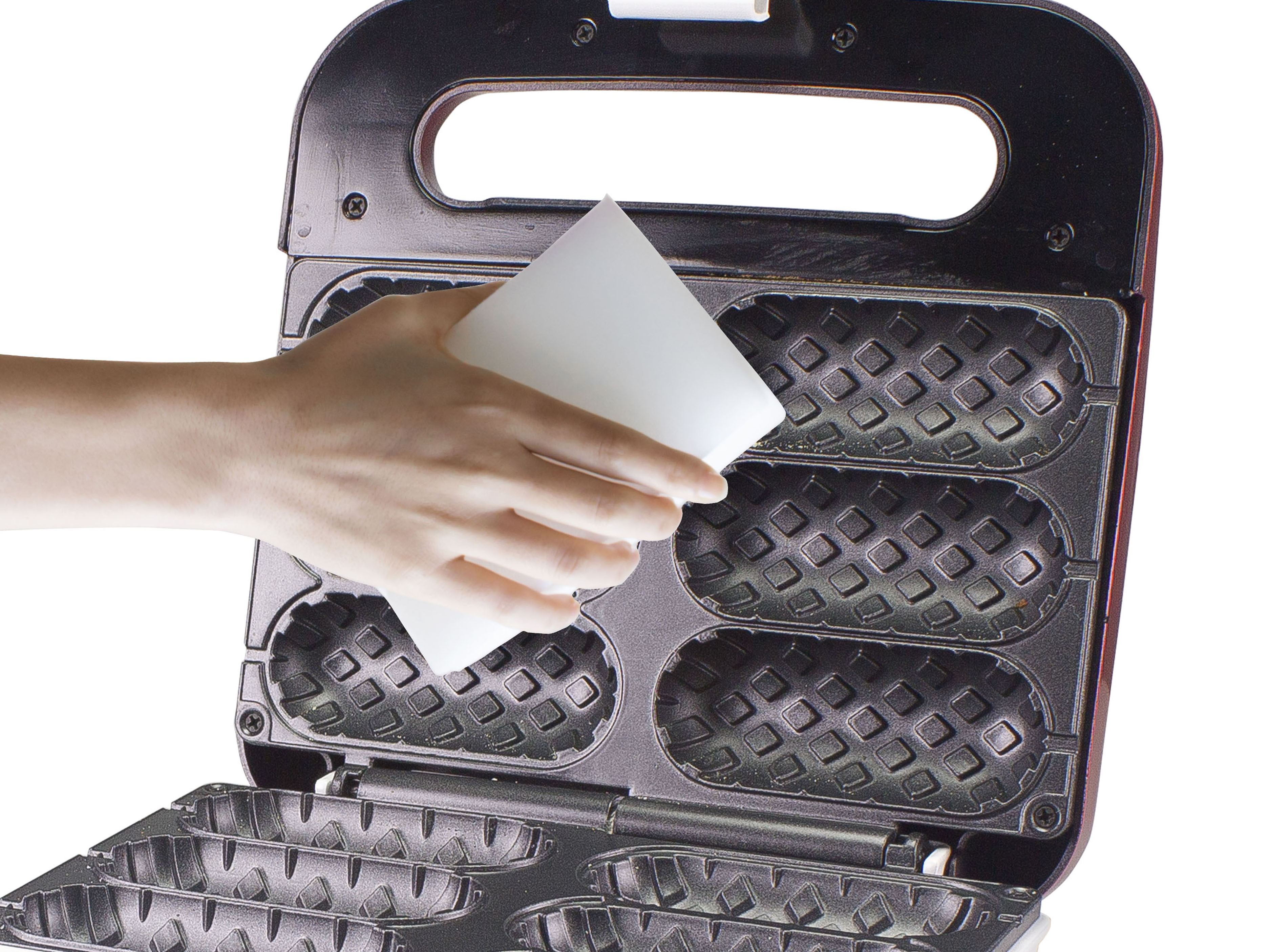 Eine Hand, die einen weißen Schwamm hält, reinigt ein Waffeleisen. Das Eisen ist offen, schwarz und hat Waffelformen.