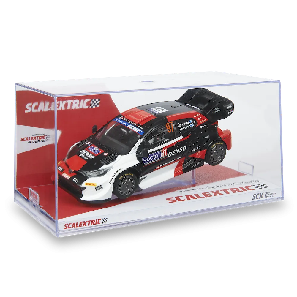 Un coche modelo Scalextric en una vitrina transparente. Es negro, rojo y blanco, con logotipos de patrocinadores. El coche está etiquetado con '97' y 'DENSO'.