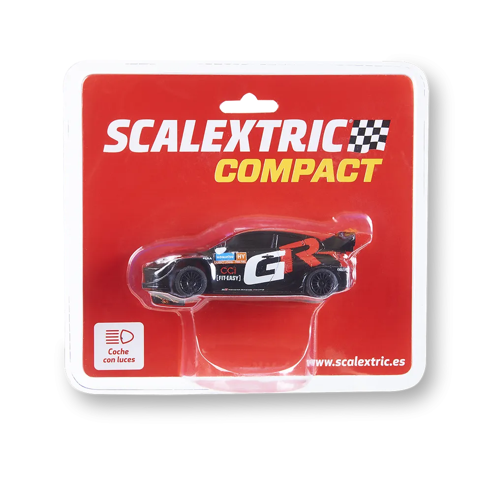 Un paquete de coches Scalextric Compact. El coche es negro con detalles rojos y blancos. El paquete es rojo con texto blanco y tiene un gráfico de coche.