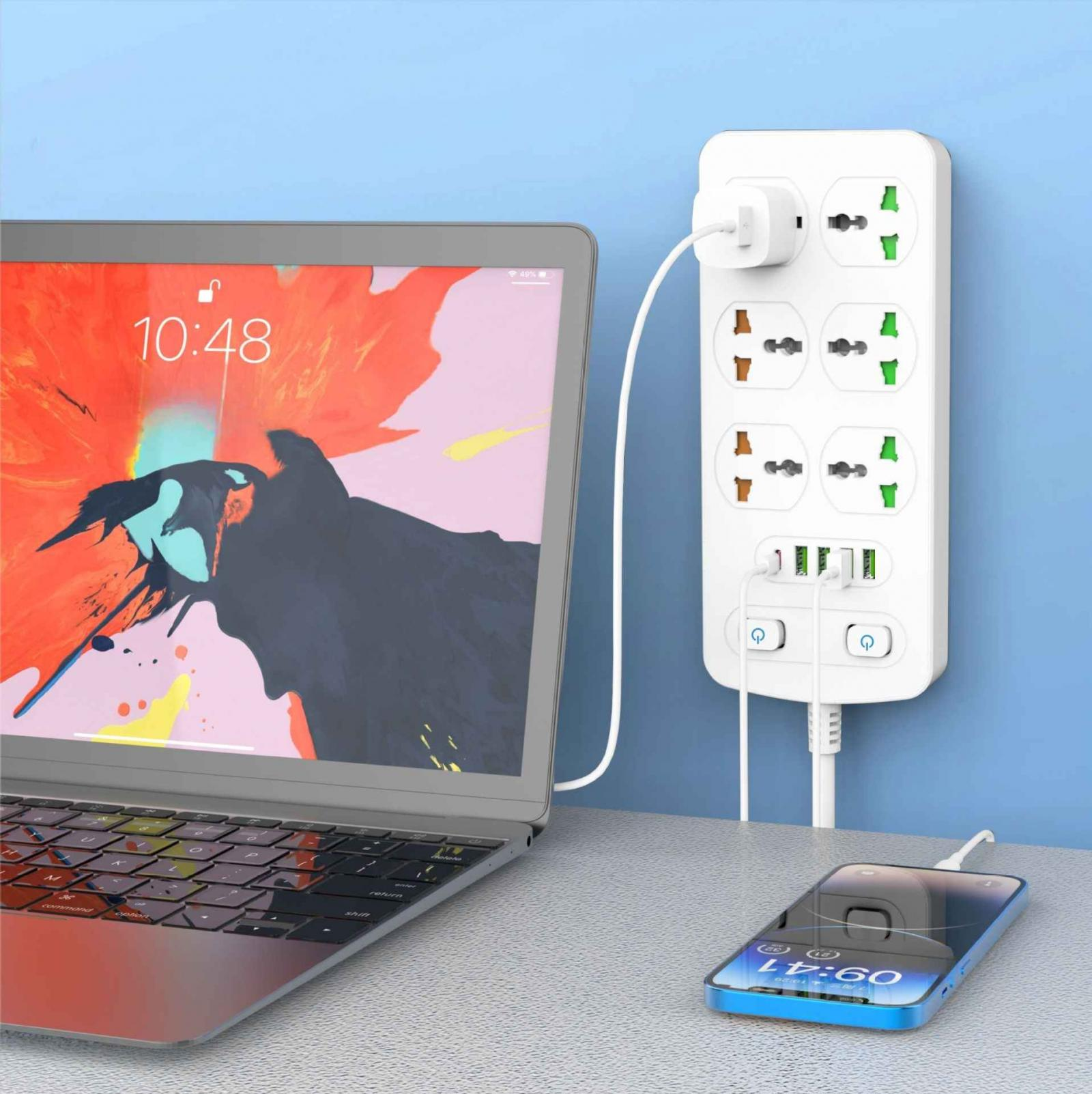 Laptop, Steckdosenleiste und Telefon laden auf einem Schreibtisch. Der Laptop zeigt 10:48. Ein Telefon zeigt 09:41.