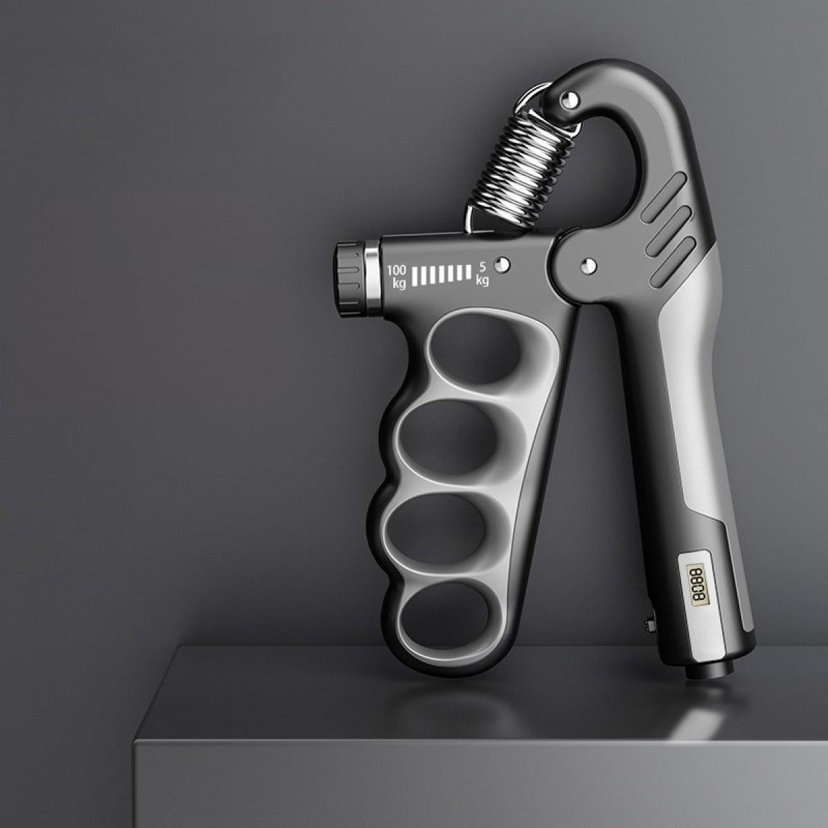 Ein Handgriffverstärker, schwarz und silber, liegt auf einer grauen Oberfläche. Er hat eine Feder und einstellbare Widerstandseinstellungen.