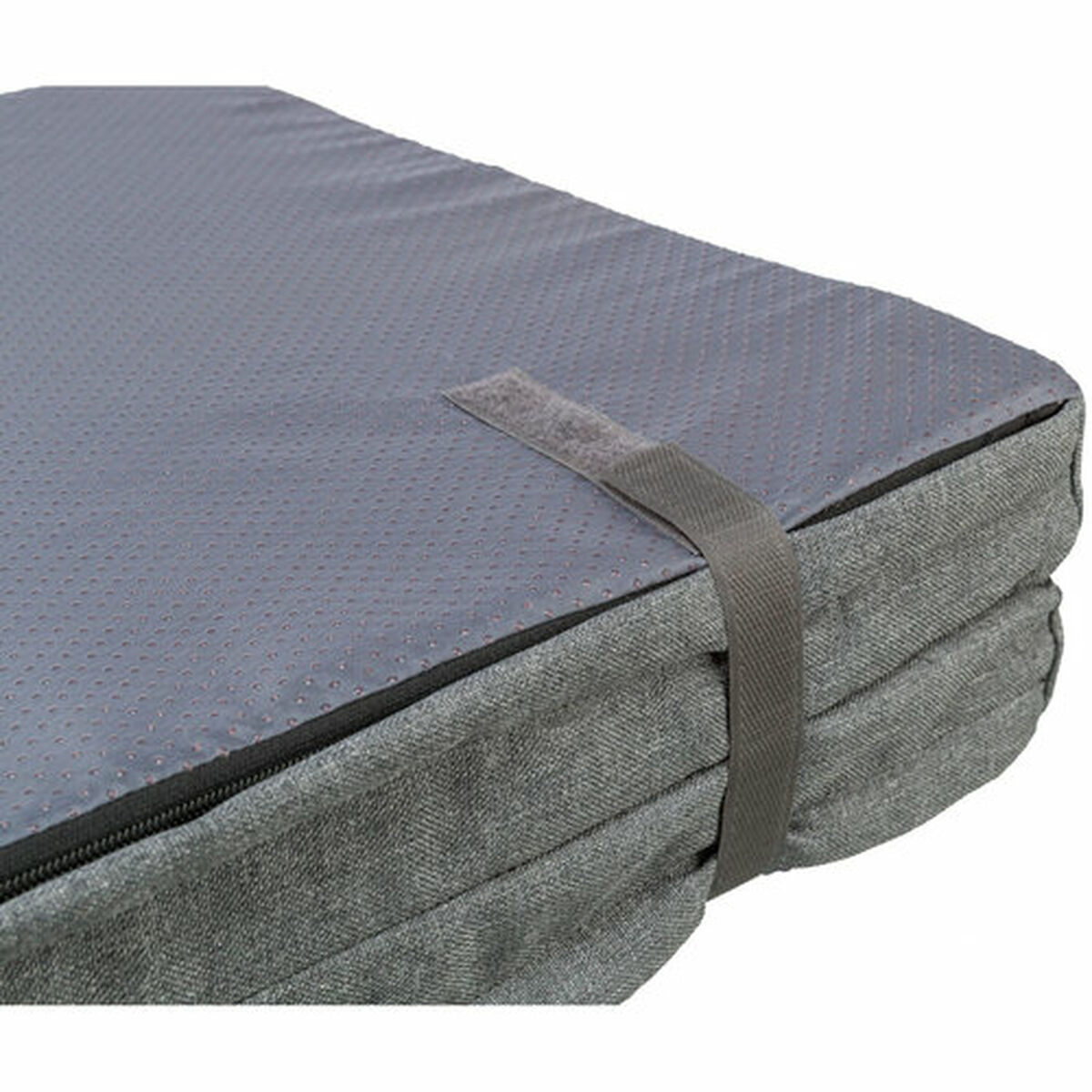 Primer plano de una cama para perros gris con una parte superior texturizada y una correa de transporte. La cama está doblada y tiene cremallera.