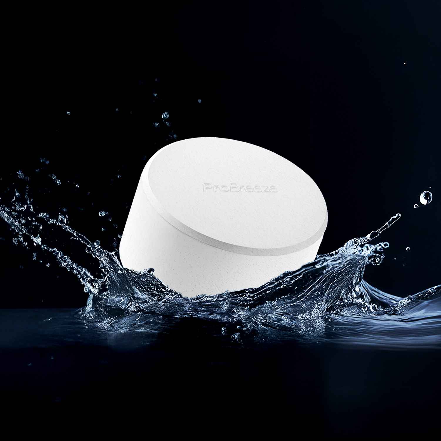 Ein weißes scheibenförmiges Objekt mit "ProBreeze" ist in Wasser getaucht. Wasser spritzt darum herum vor dunklem Hintergrund.