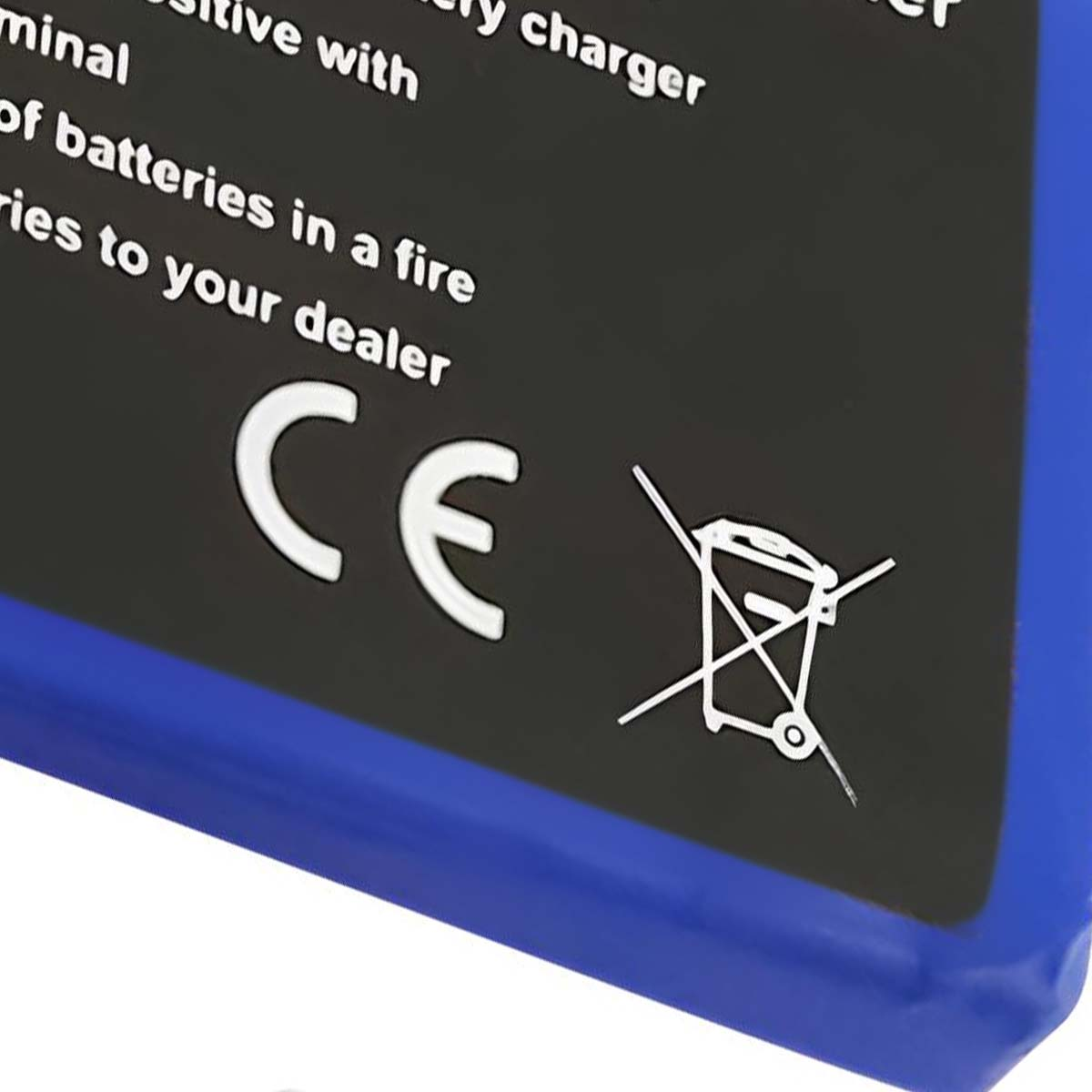 Eine schwarze Oberfläche mit weißem Text und einem CE-Symbol. Ein durchgestrichenes Mülleimersymbol ist ebenfalls vorhanden.