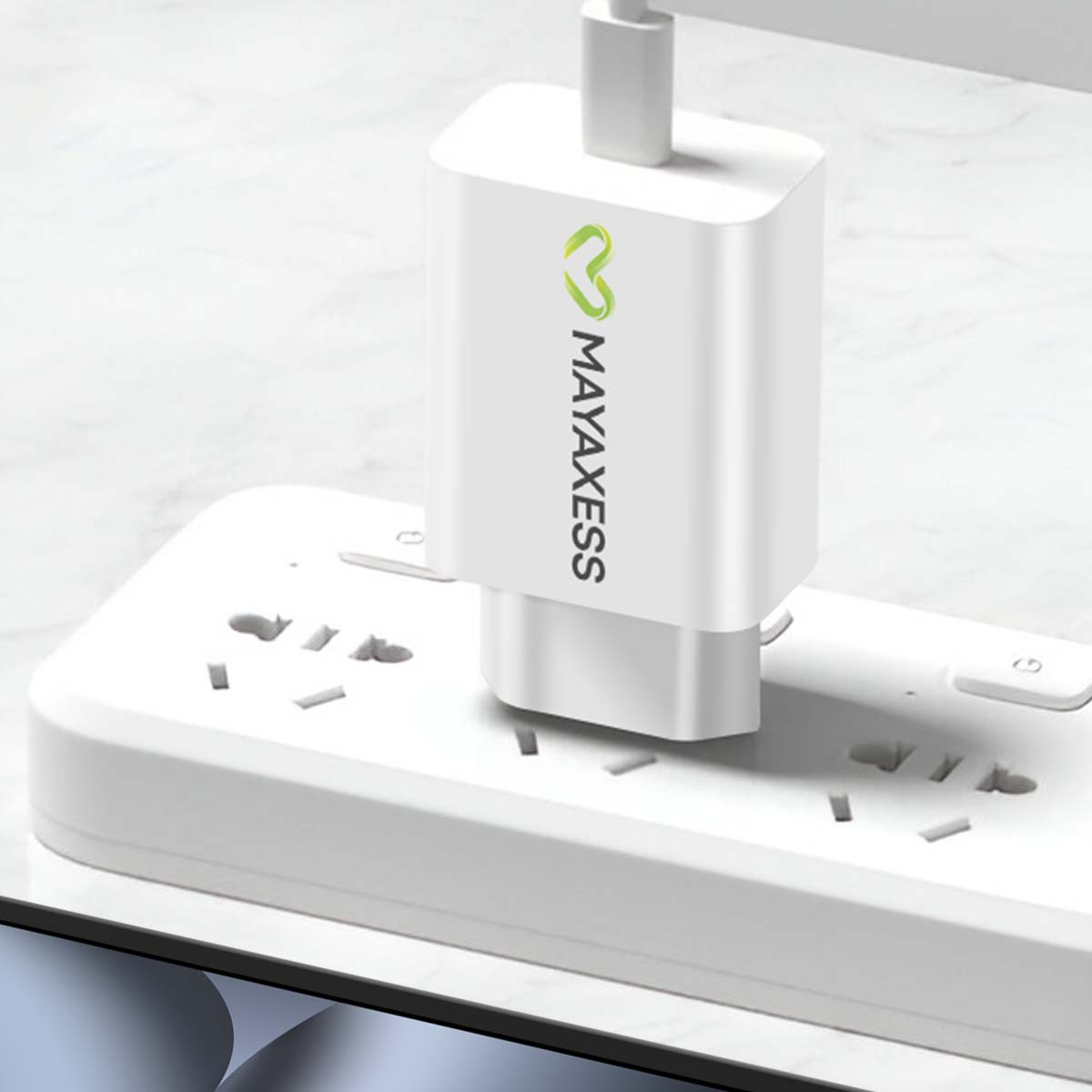 Un caricabatterie MAYAXESS bianco collegato a una presa multipla bianca. Il caricabatterie ha un logo verde e un cavo USB.