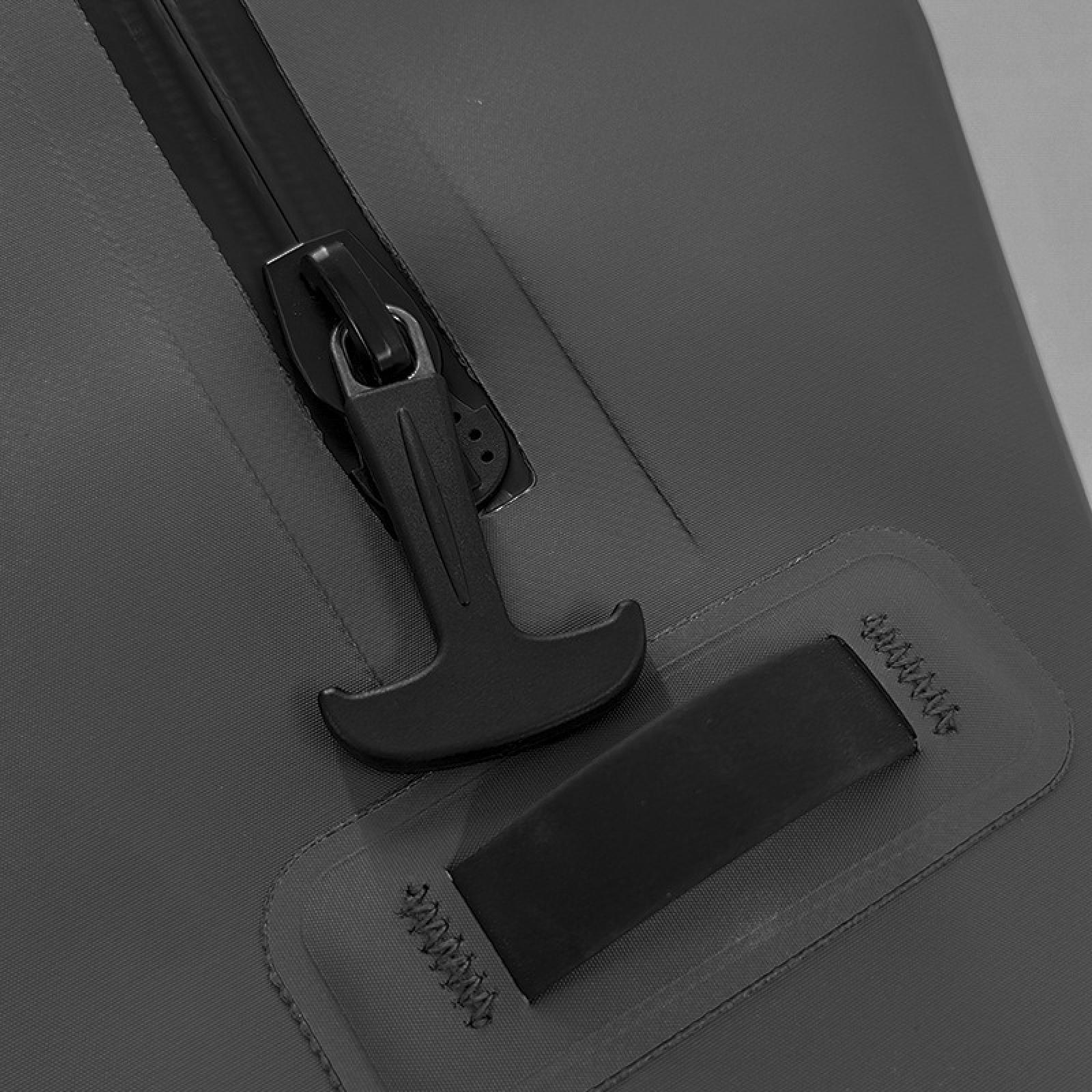 Nahaufnahme einer grauen Tasche mit schwarzem Reißverschluss und Griff. Ein schwarzer Riemen ist an die Tasche genäht.