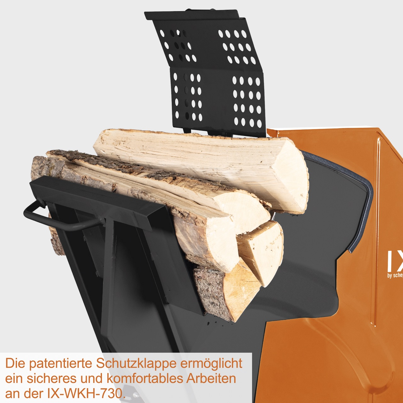 Ein Holzspalter mit Schutzklappe, der Holz hält. Der Spalter ist schwarz und orange. Das Holz ist hellbraun.