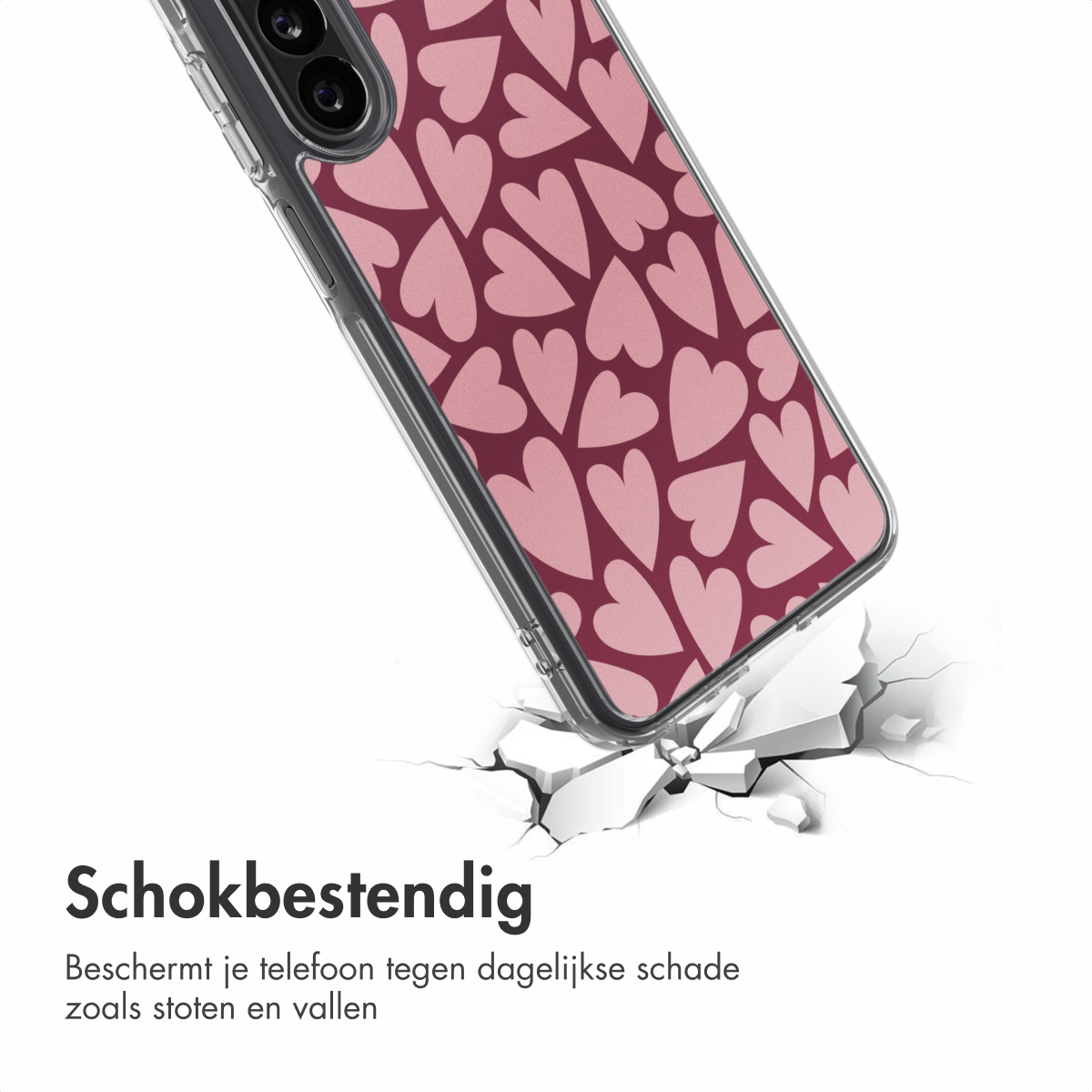 Een telefoonhoesje met roze hartjes op een bordeauxrode achtergrond breekt een wit oppervlak. De hoes is transparant.