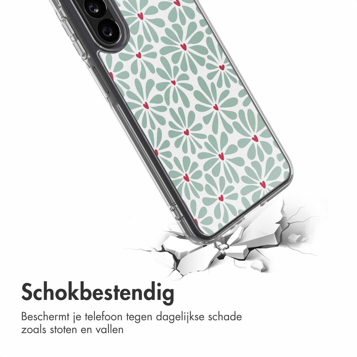 Een telefoonhoesje met bloemenpatroon, rustend op gebroken stukken van een wit oppervlak. De hoes is transparant, met groene bloemen en rode harten.