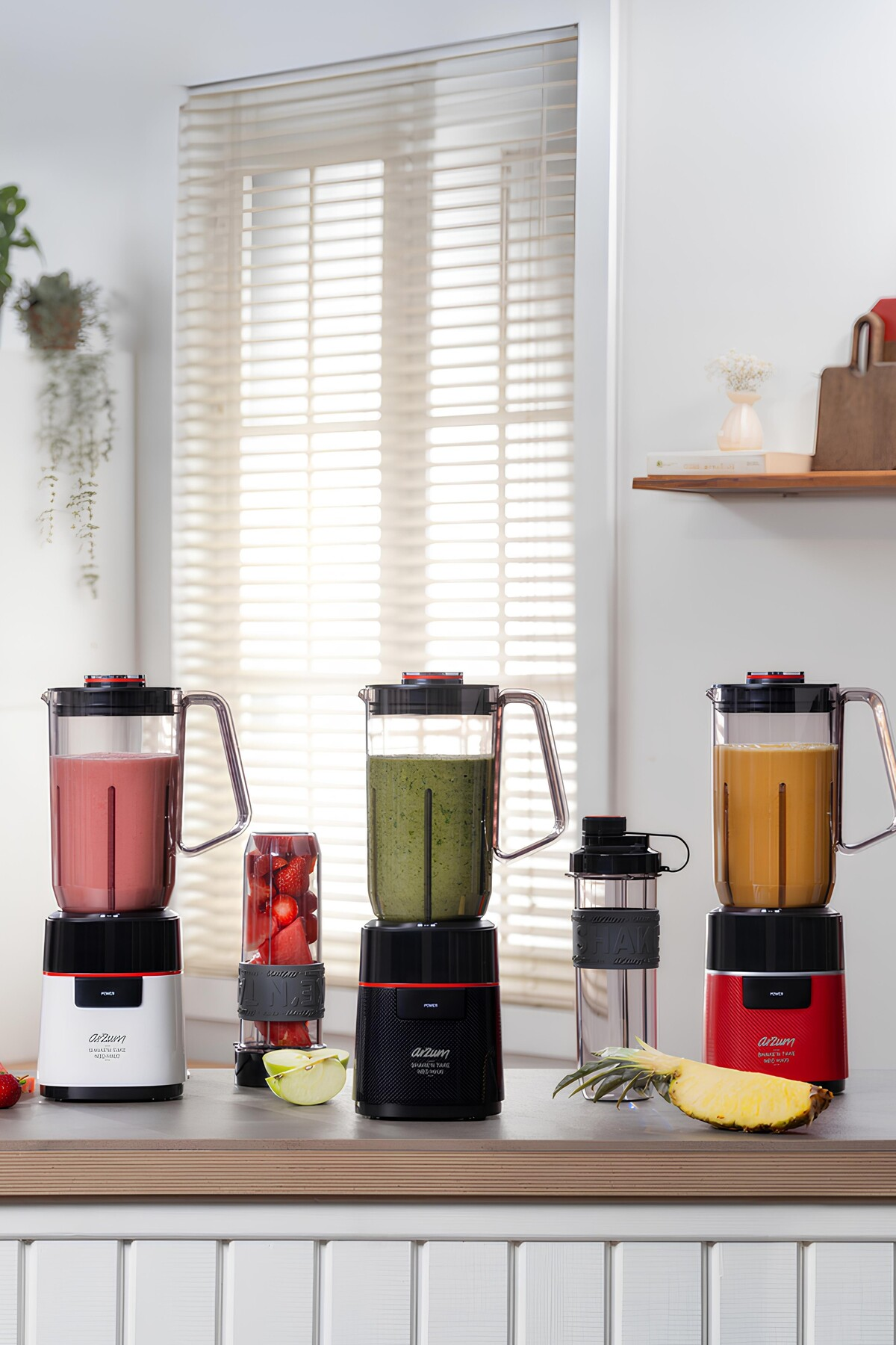 Smoothie'lerle karıştırıcılar, bir çalkalayıcı, bir ananas dilimi ve meyveler. Sahne, panjurlu bir pencere ve dekorlu bir raf içeriyor.