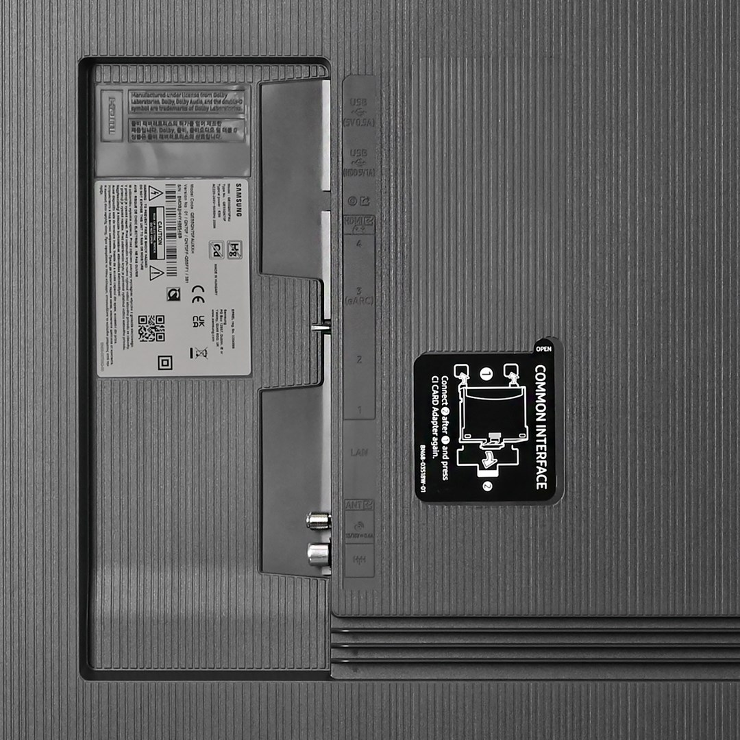Tył telewizora Samsung z portami, etykietami i gniazdem 'Common Interface'. Powierzchnia jest teksturowana, ciemnoszara.