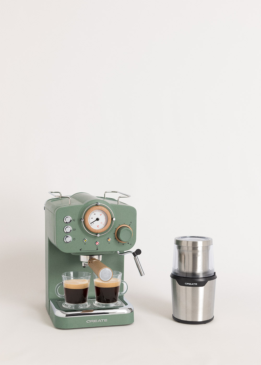 Máquina de espresso verde con dos tazas de espresso y un molinillo sobre fondo blanco. La máquina es de la marca CREATE.