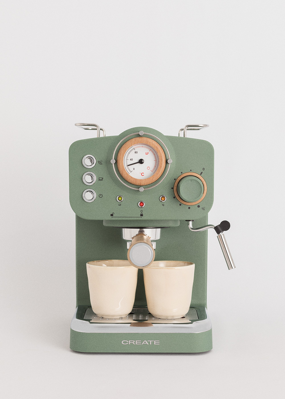 Máquina de espresso verde con dos tazas. Tiene un dial de madera y un indicador de temperatura. El fondo es blanco.