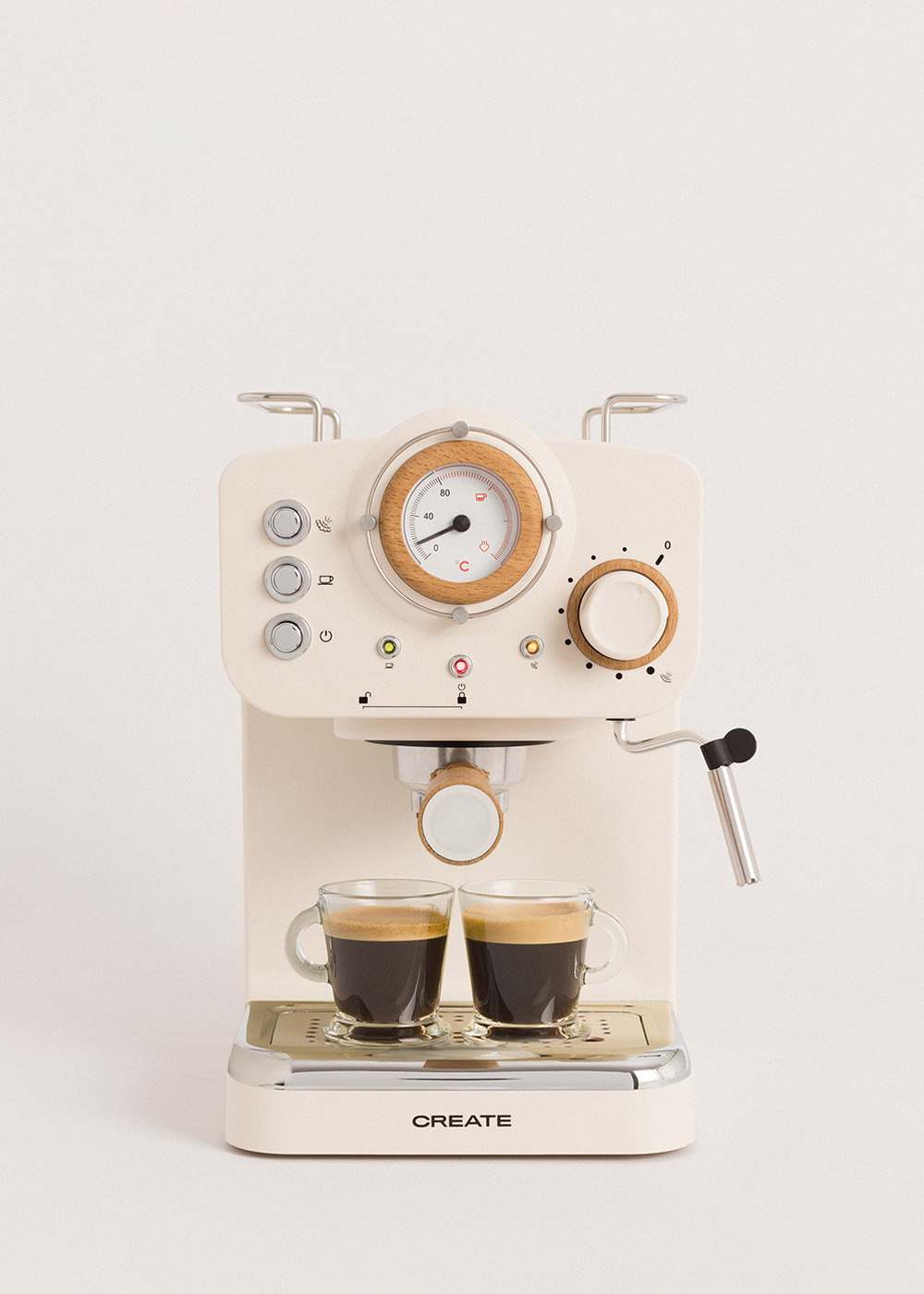 Máquina de espresso crema con dos tazas de café de vidrio. La máquina tiene detalles de madera y un indicador. Fondo blanco.