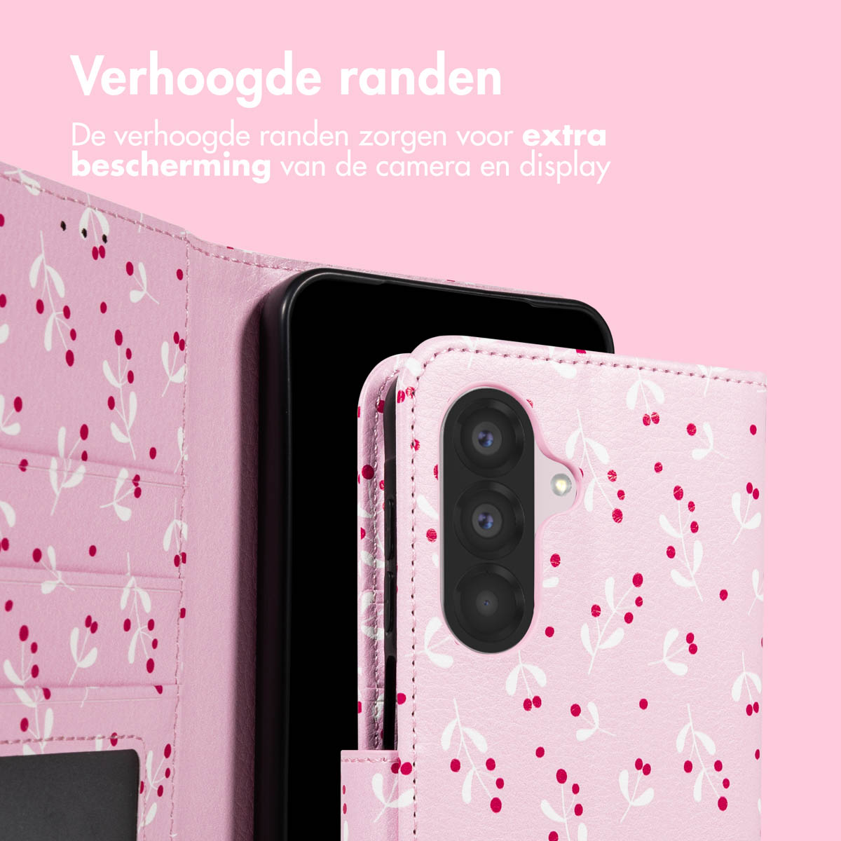 Roze telefoonhoesje met wit bloemenpatroon, beschermt een zwarte telefoon. Tekst in het Nederlands: 'Verhoogde randen voor extra bescherming'.