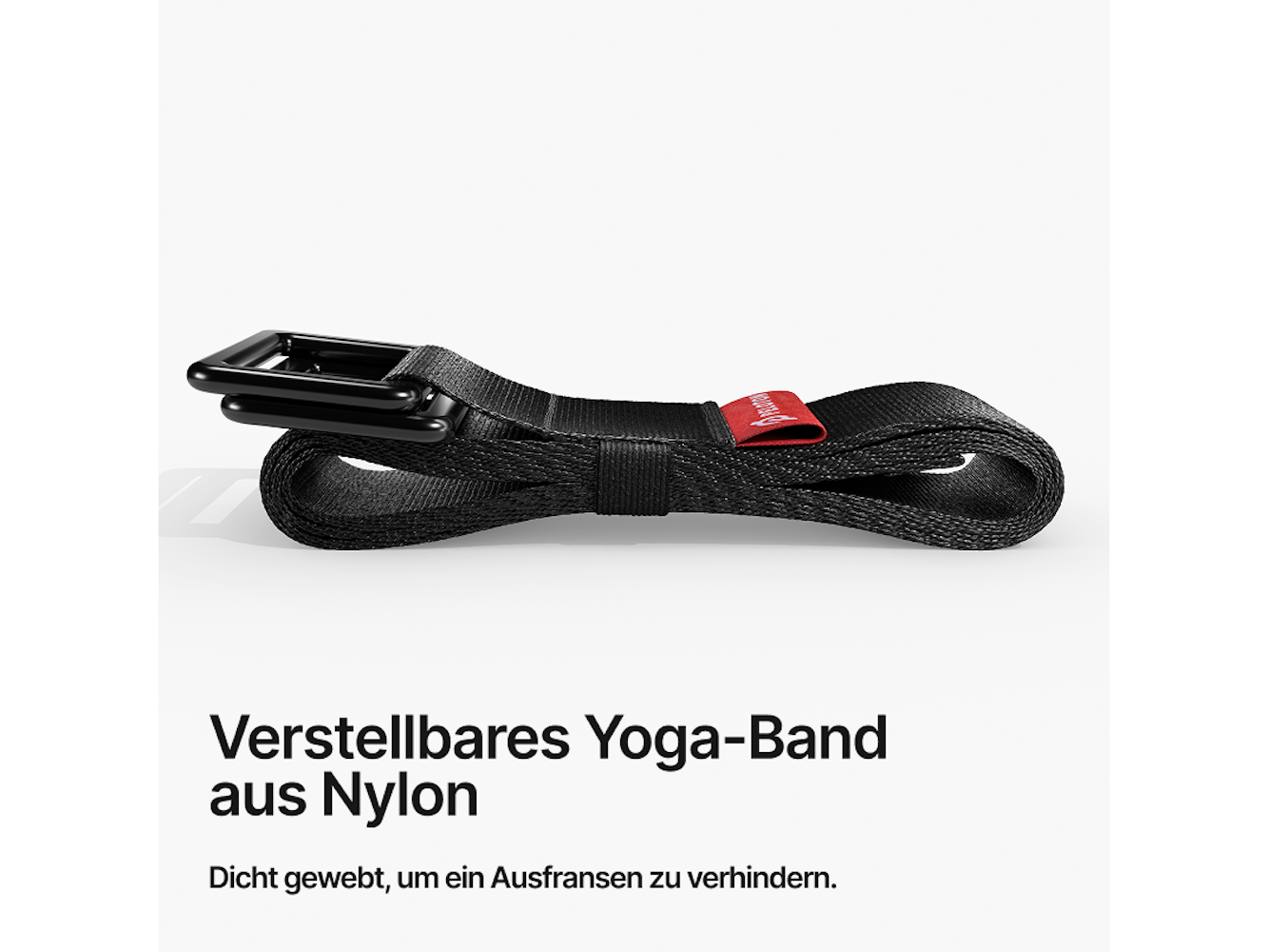 Schwarzer Yoga-Gurt aus Nylon mit schwarzer Metallschnalle und rotem Etikett. Der Gurt liegt auf weißem Untergrund.